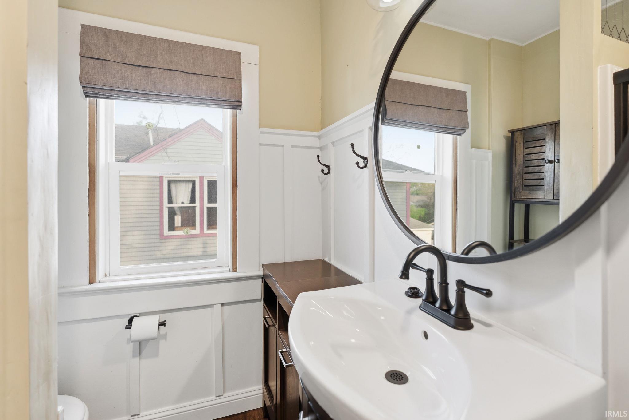 Bathroom with a decorative wall and wainscoting