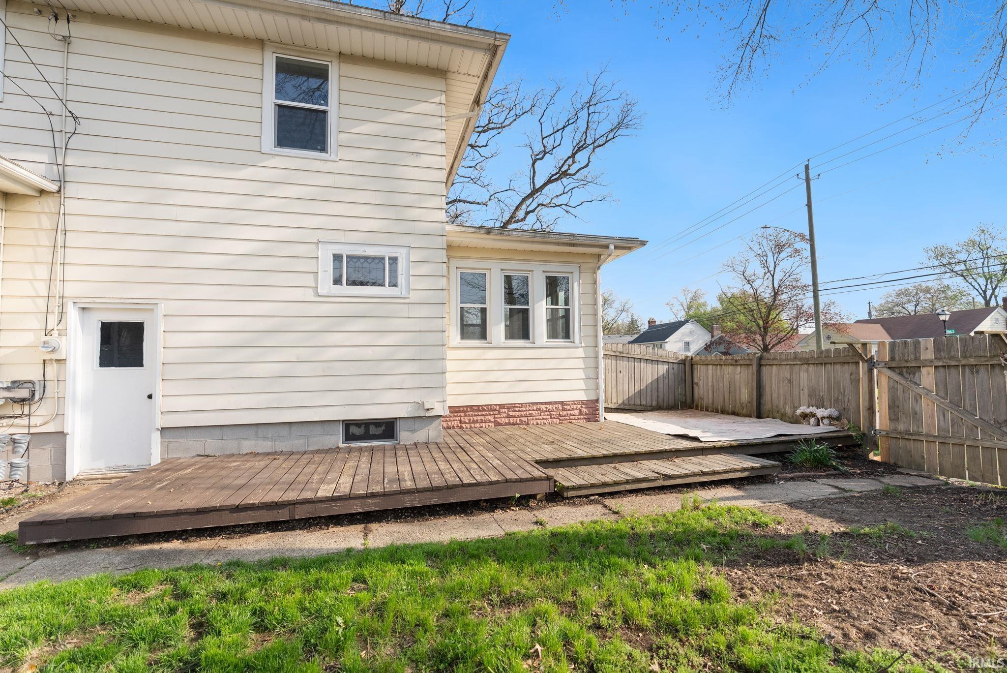 Rear view of property featuring a deck and a fenced backyard