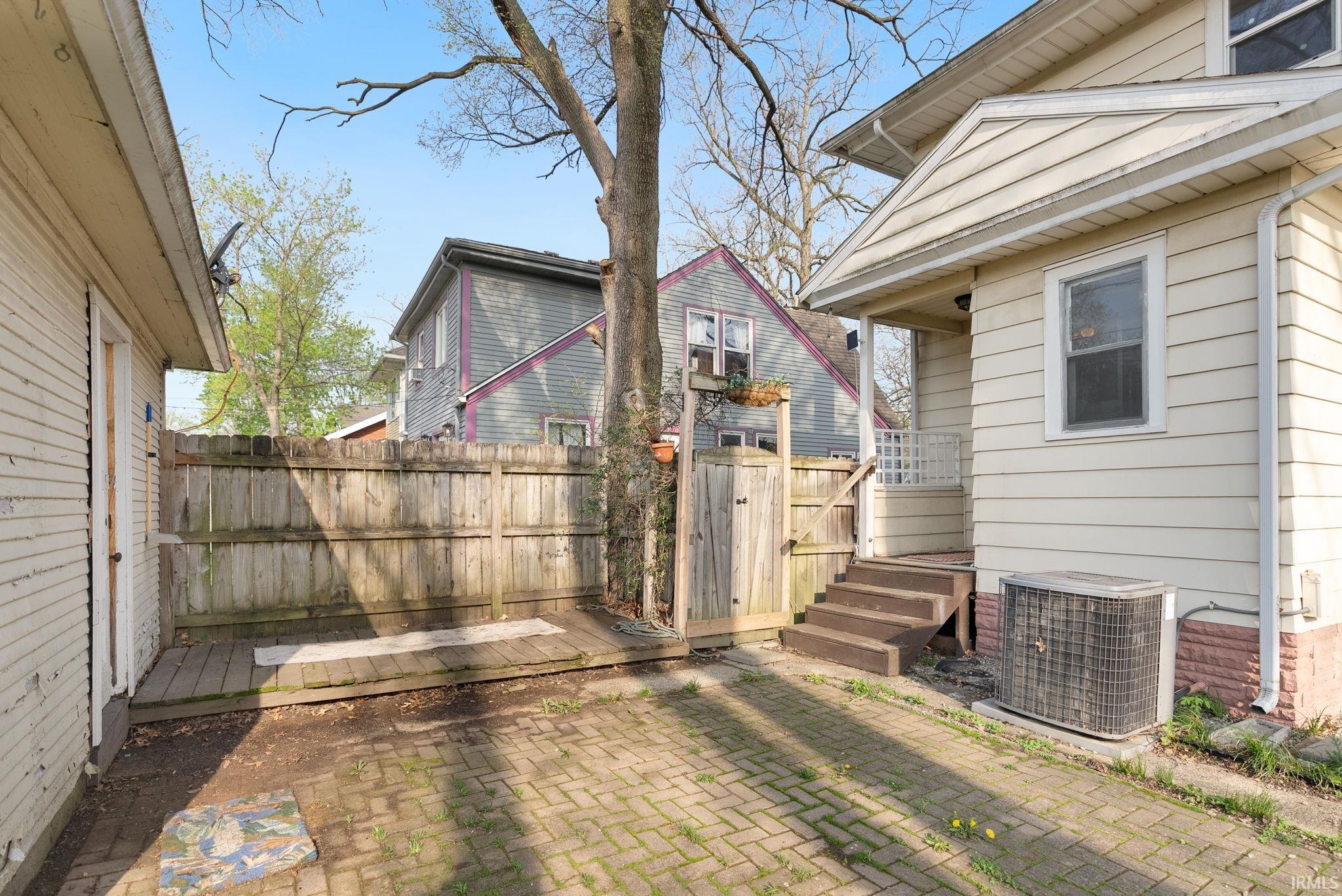 Fenced yard featuring a gate, a patio area, and a wooden deck