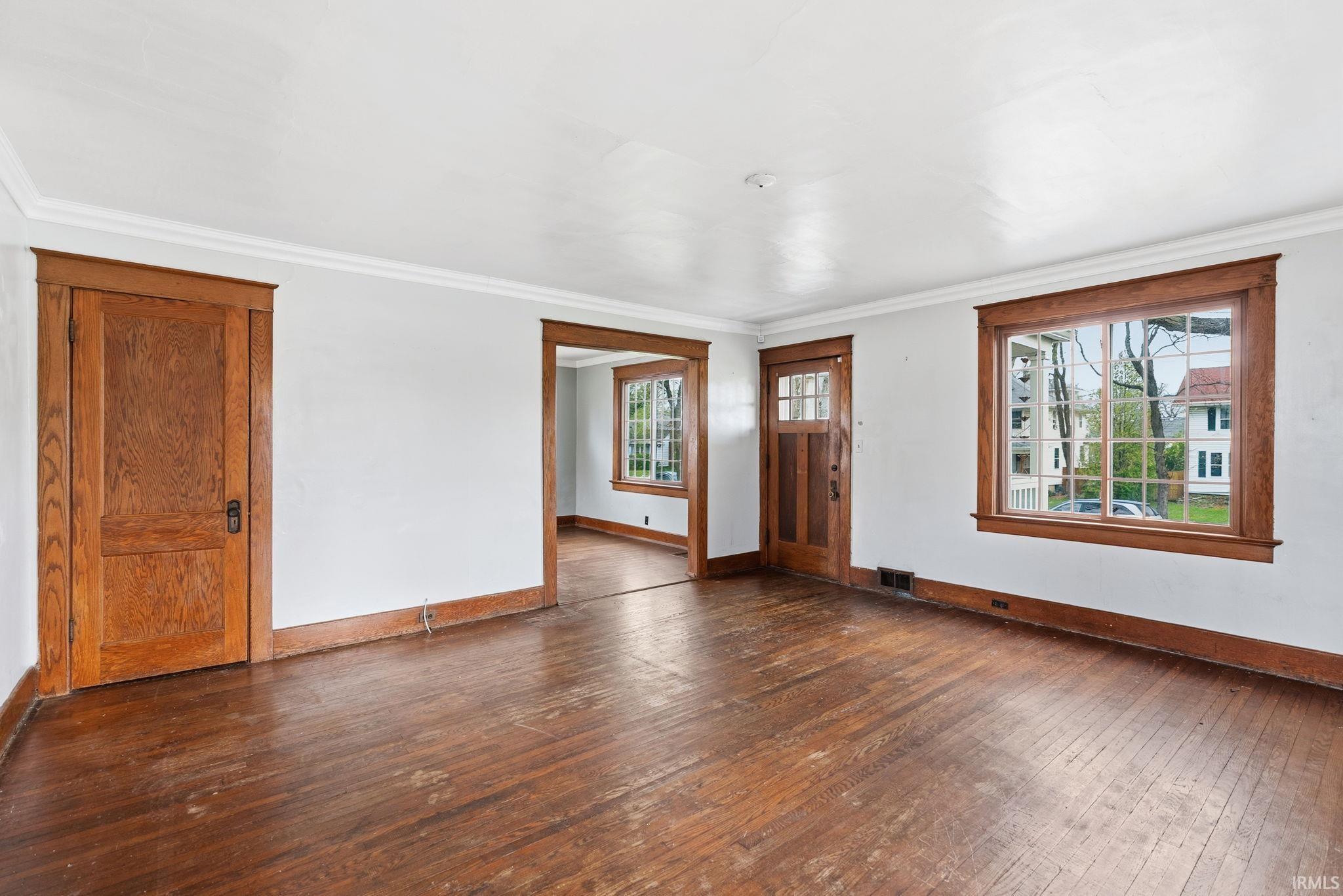 Foyer entrance featuring dark wood finished floors and ornamental molding