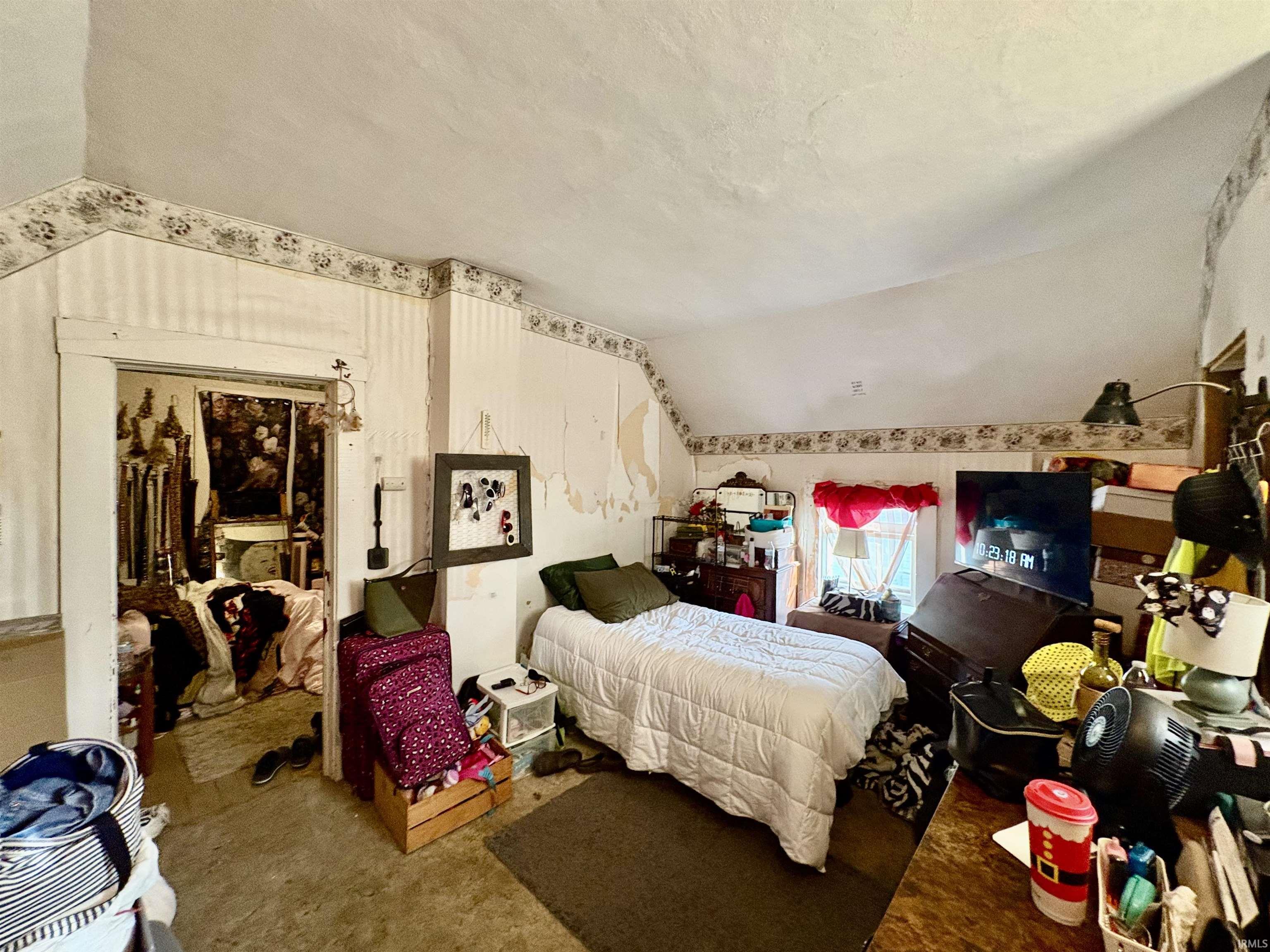 Bedroom with lofted ceiling and a closet