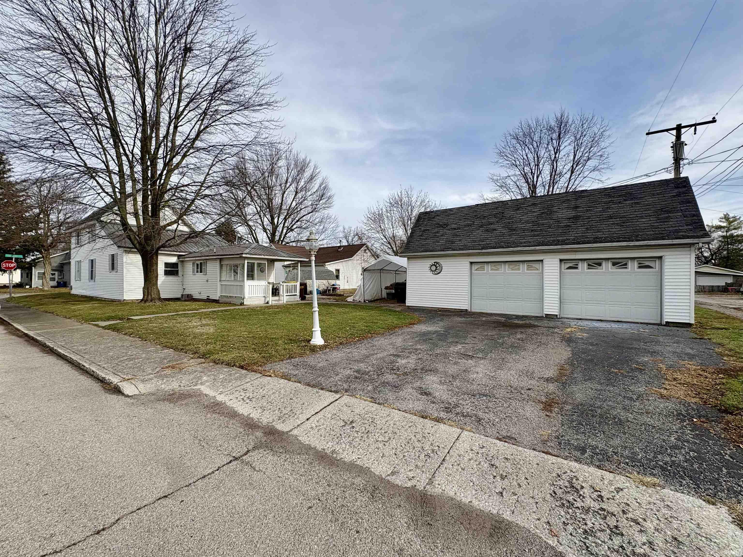 View of front of house with an outbuilding, a front yard, and a garage