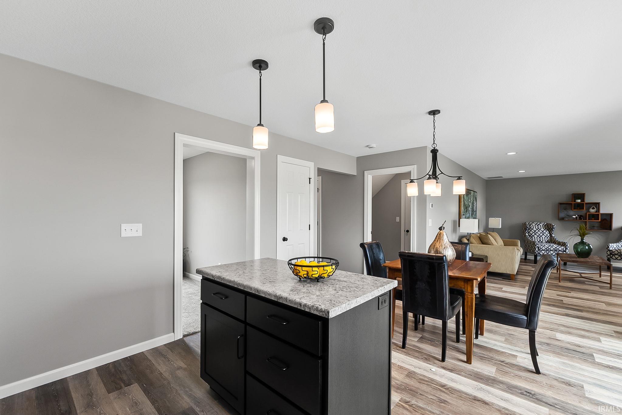Kitchen island with a light-colored countertop and dark cabinetry