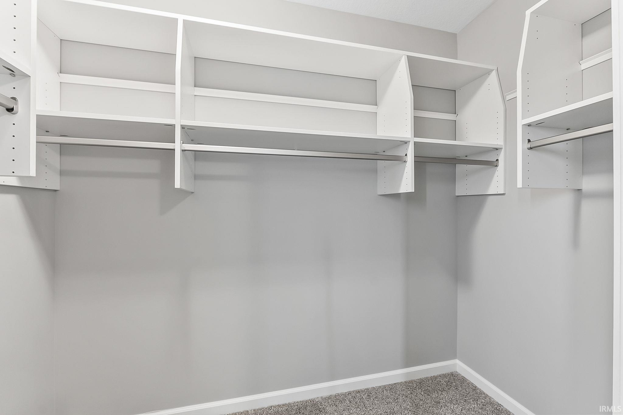 Custom closet system featuring white shelving and hanging rods