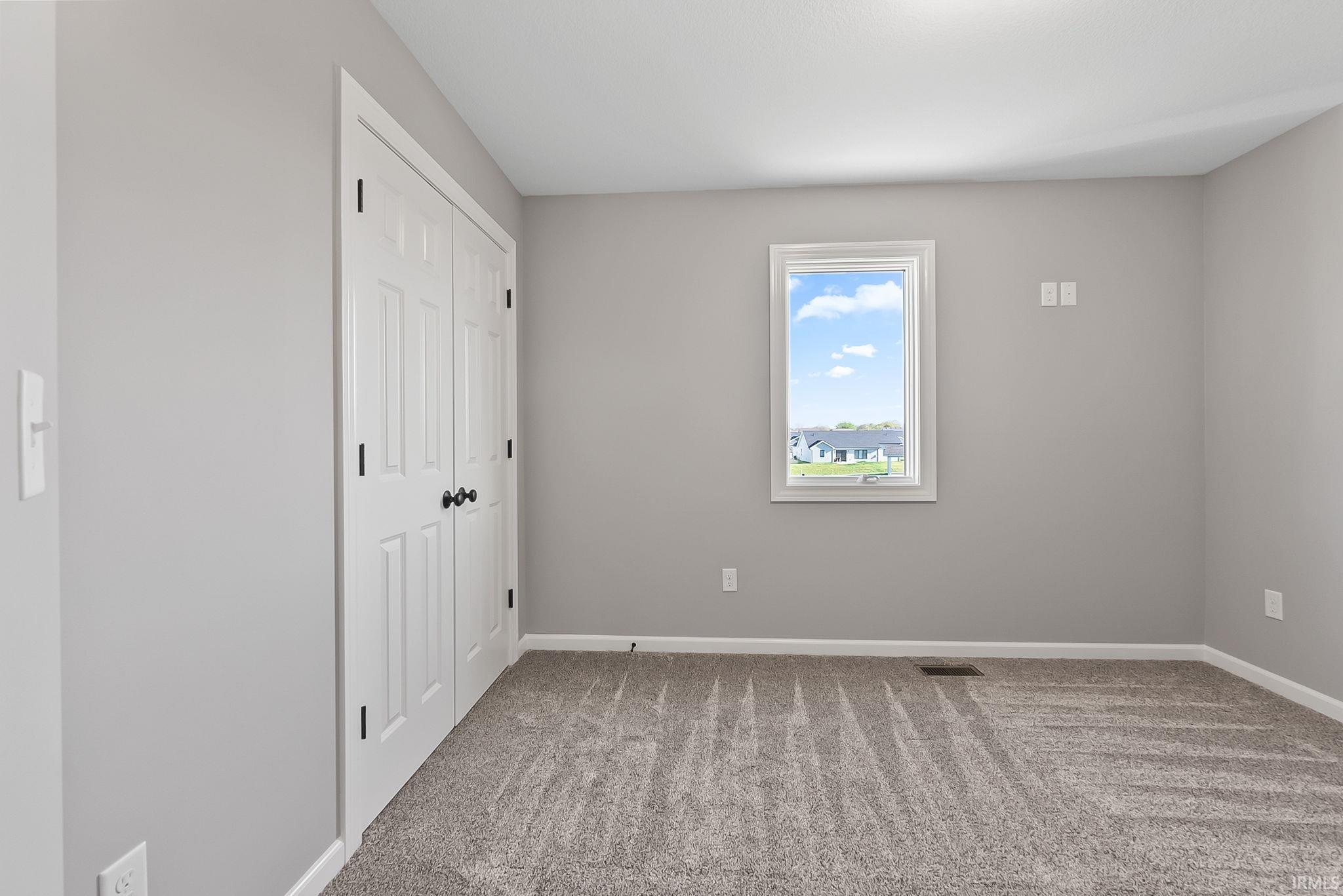 Unfurnished bedroom featuring light colored carpet and a closet