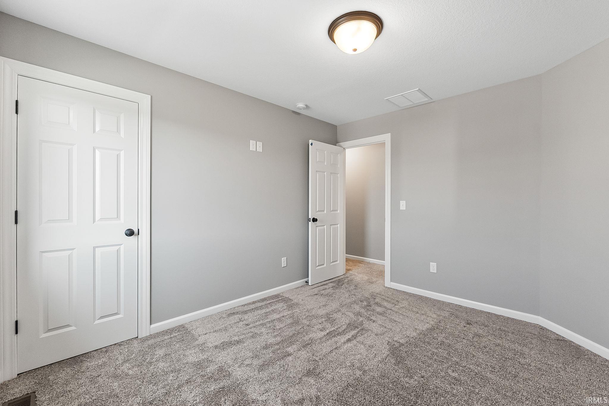 Unfurnished bedroom with baseboards and light colored carpet