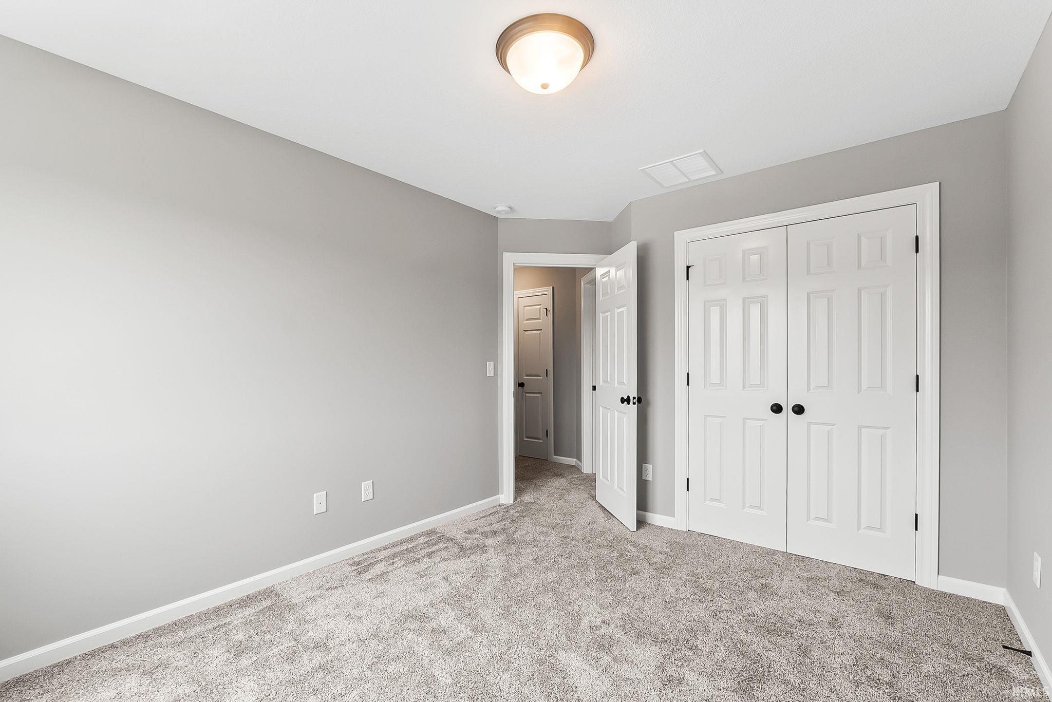Bedroom featuring neutral gray walls and gray carpet flooring