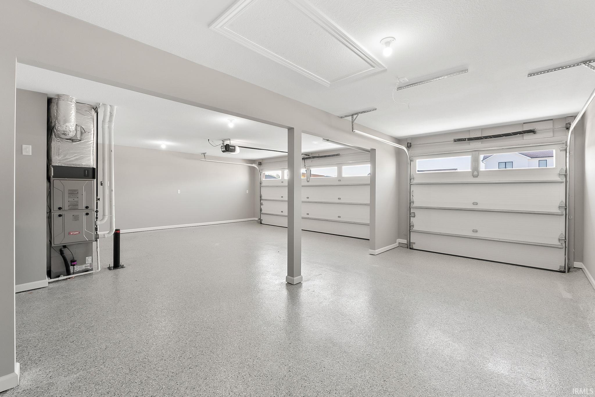 Garage featuring baseboards and heating unit