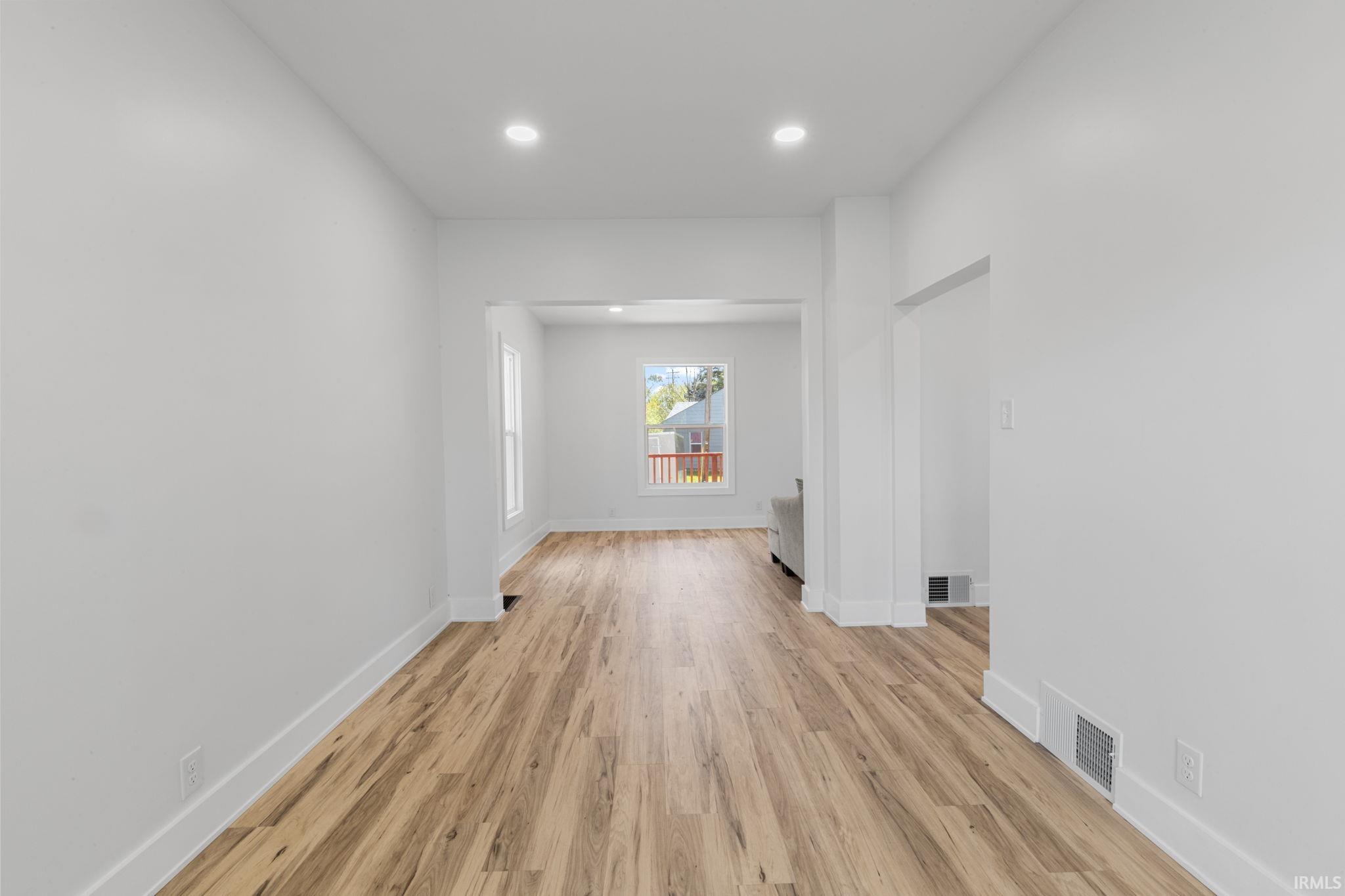 Empty room featuring light wood finished floors and recessed lighting