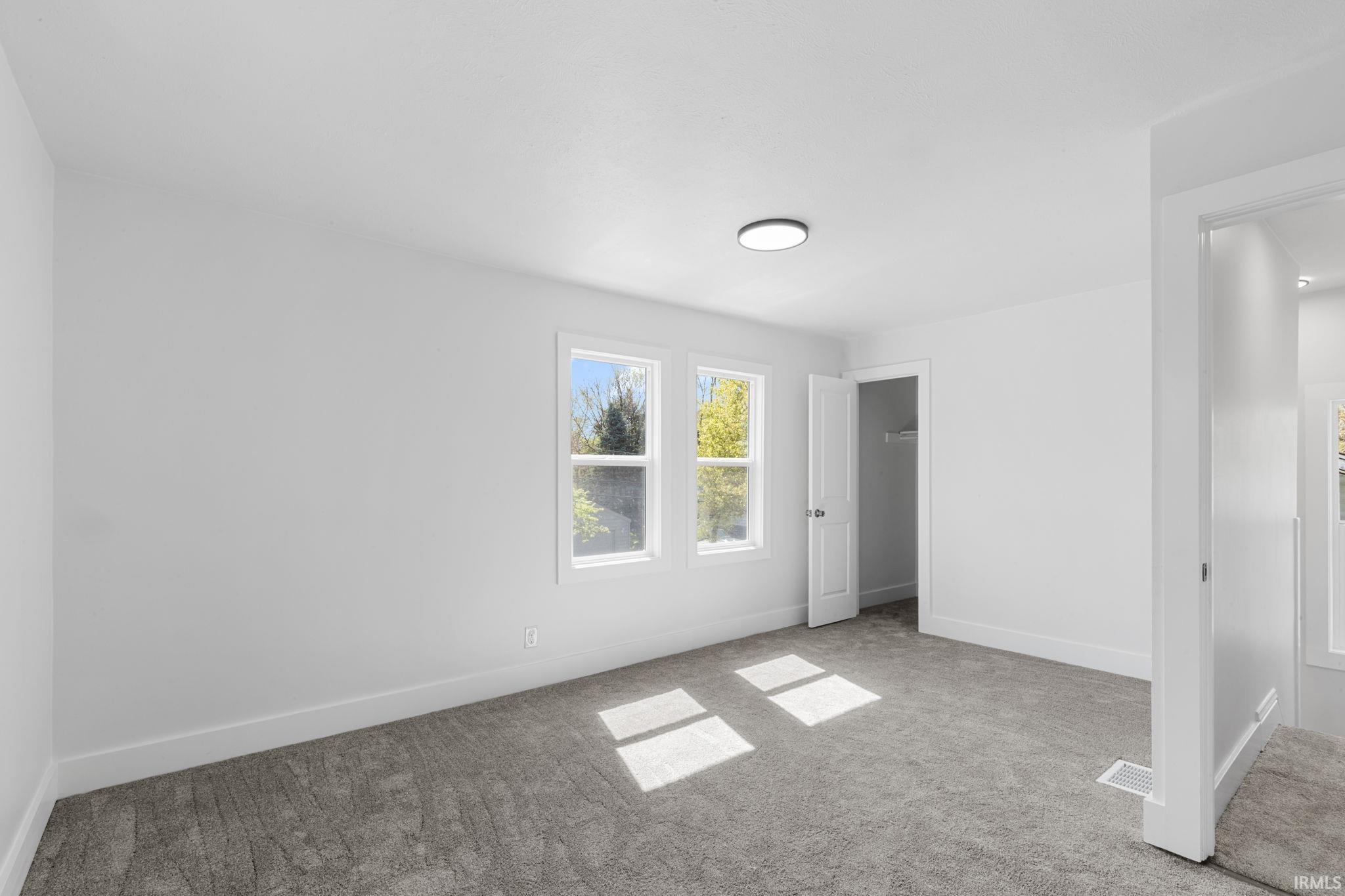 Unfurnished bedroom featuring light carpet and a closet