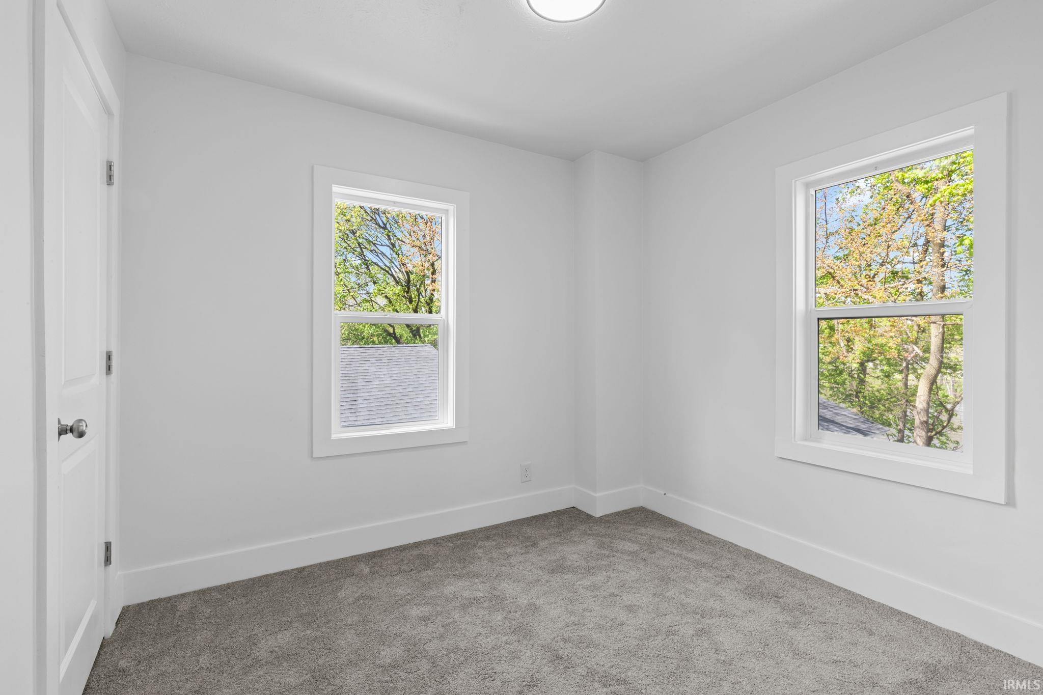 Unfurnished room featuring baseboards and carpet flooring