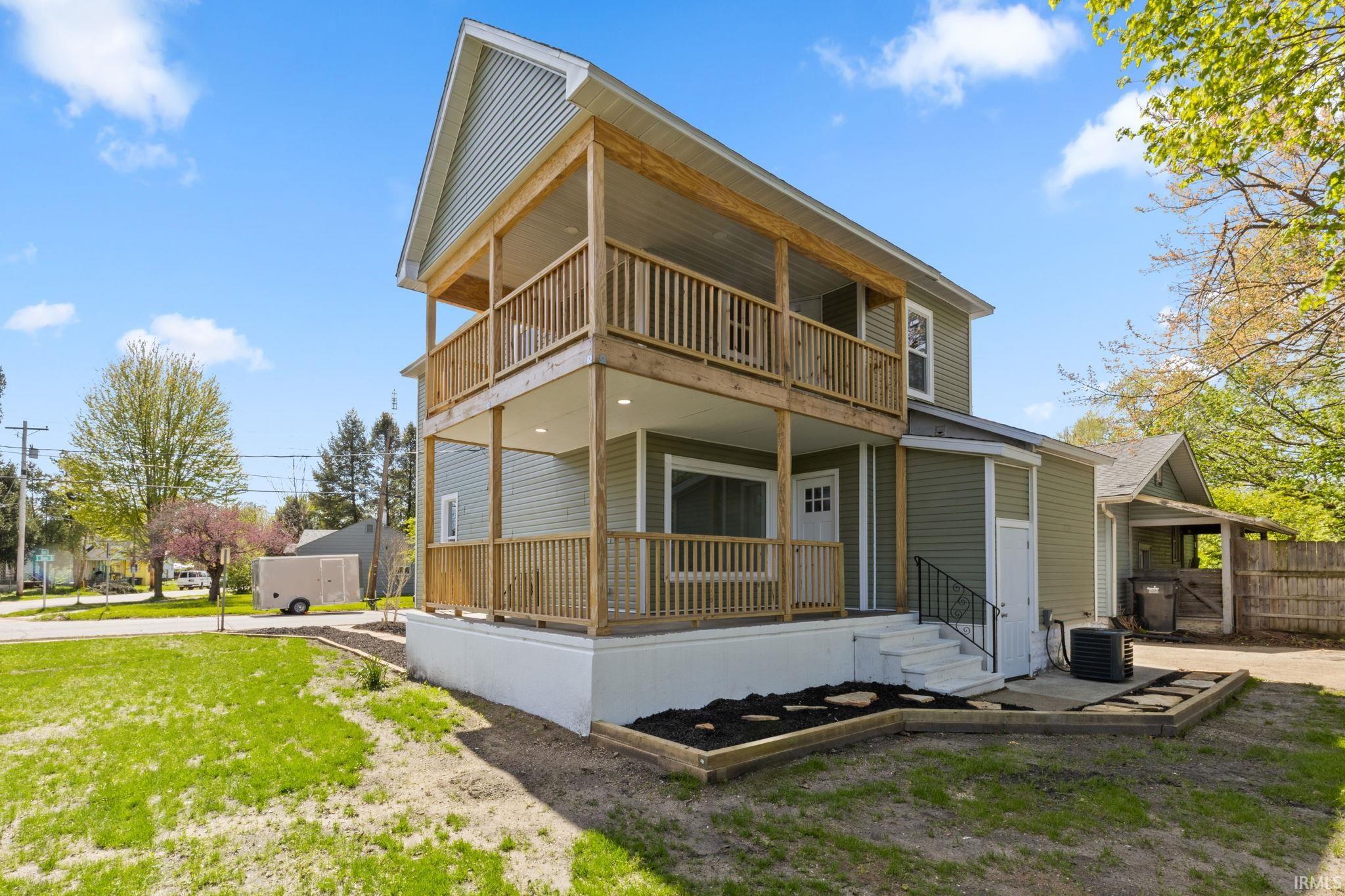 Back of house with a porch and a lawn