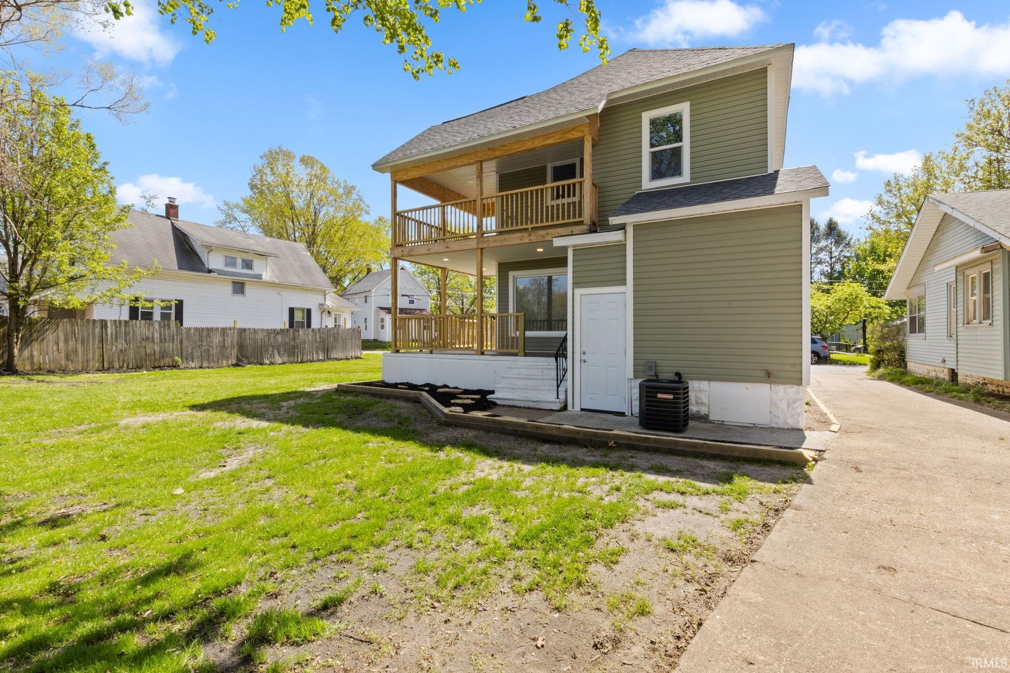 Back of property with a shingled roof and a balcony