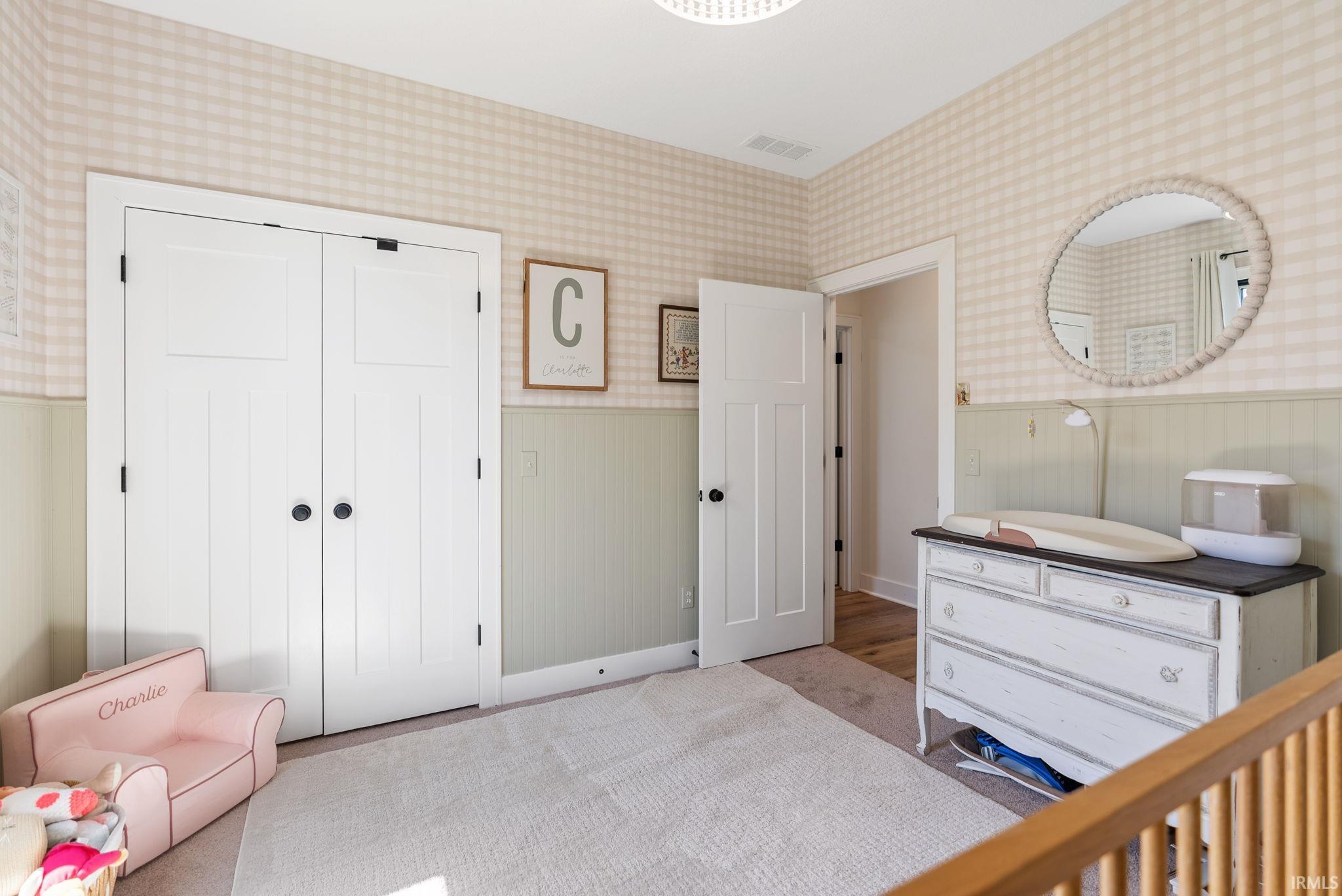 Bedroom featuring a recessed double-door closet with black hardware, a single panel interior door, and a round overhead light fixture