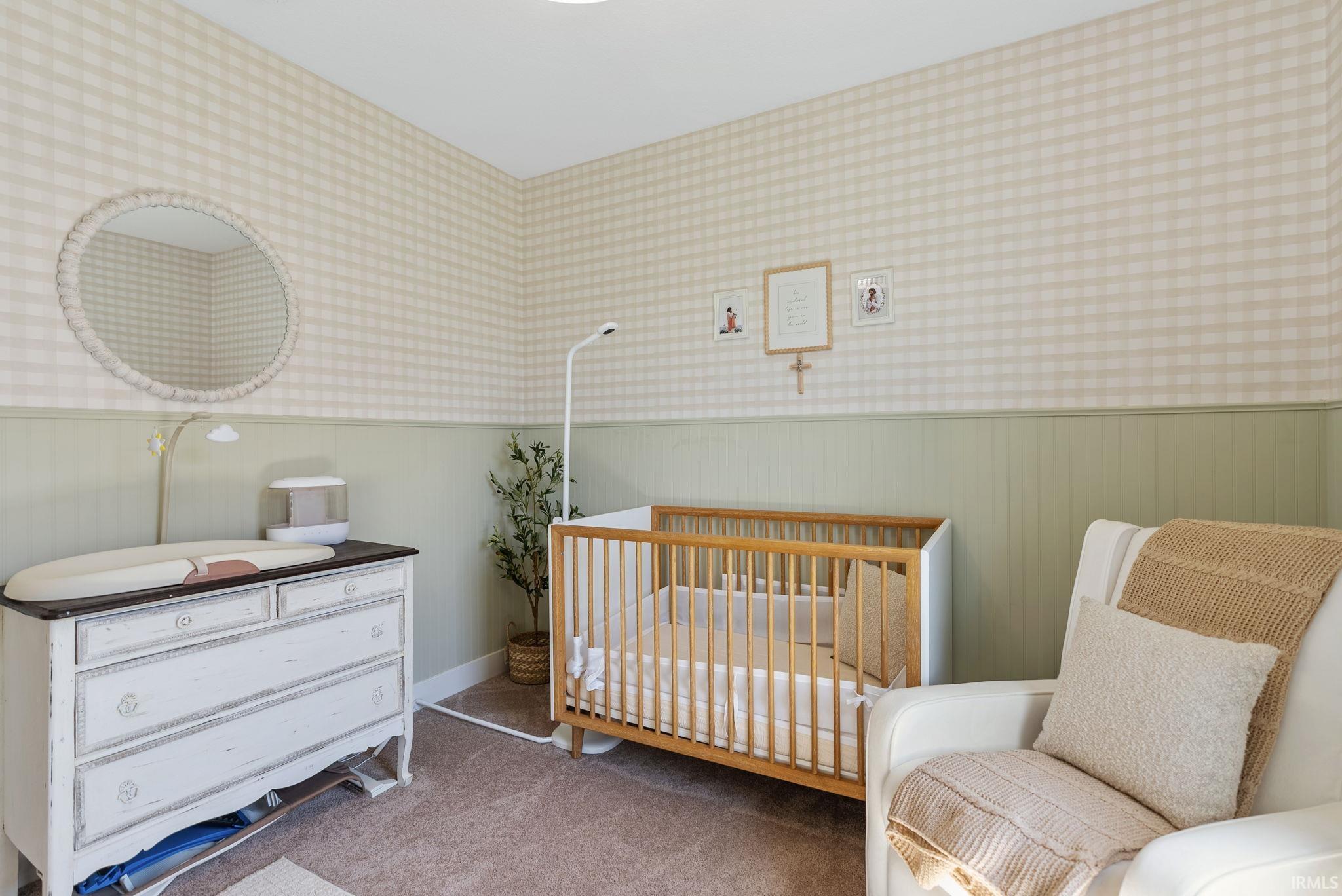 Room featuring two-tone wall treatment with a green lower panel and light plaid wallpaper