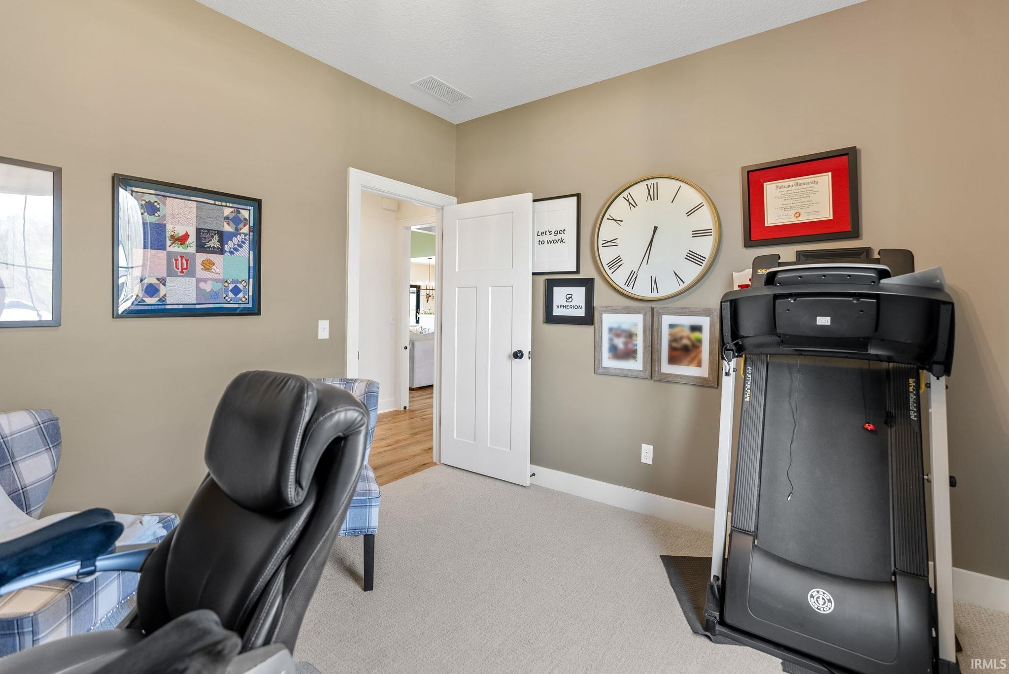Carpeted interior room with neutral-toned walls
