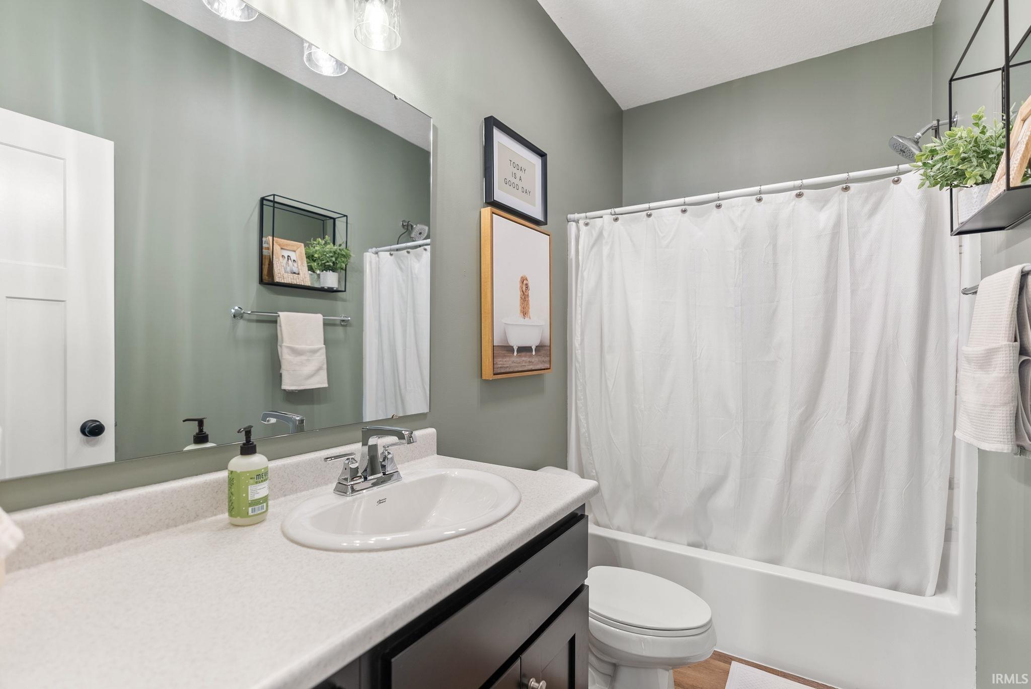 Bathroom featuring a single vanity with an integrated sink, laminate countertop, and dark wood-finish cabinetry