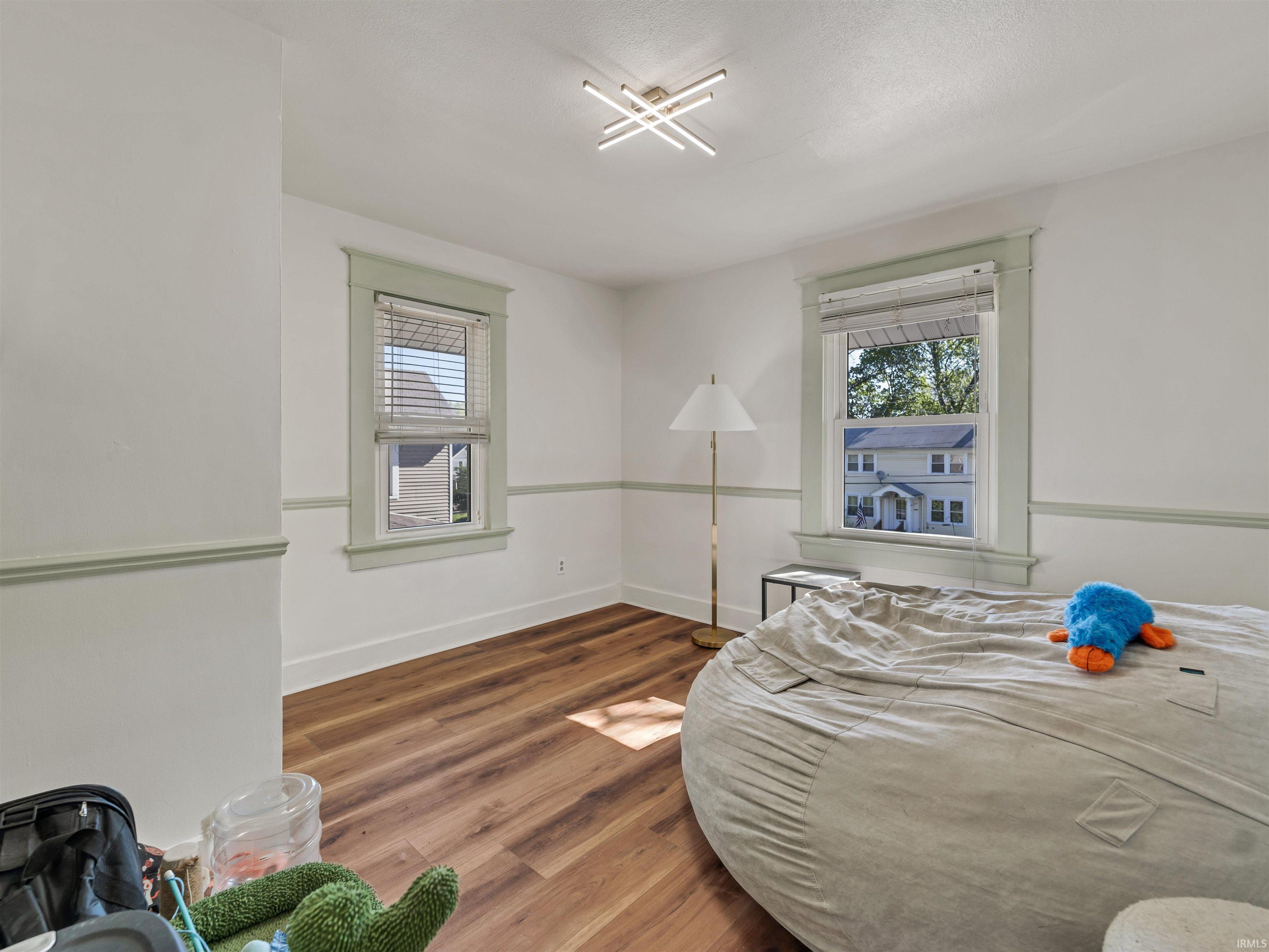 Bedroom with wood finished floors and baseboards