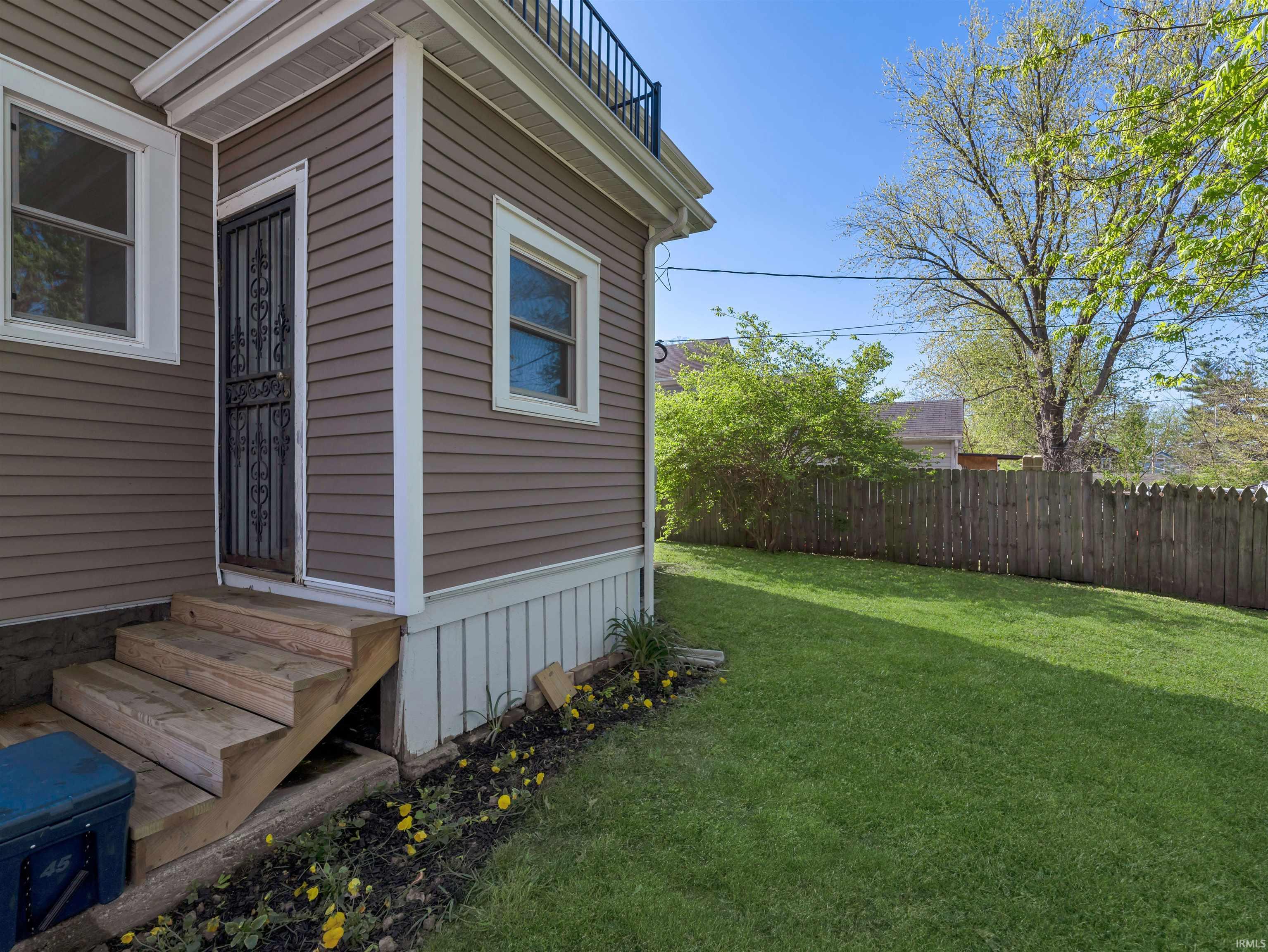 Fenced backyard featuring entry steps