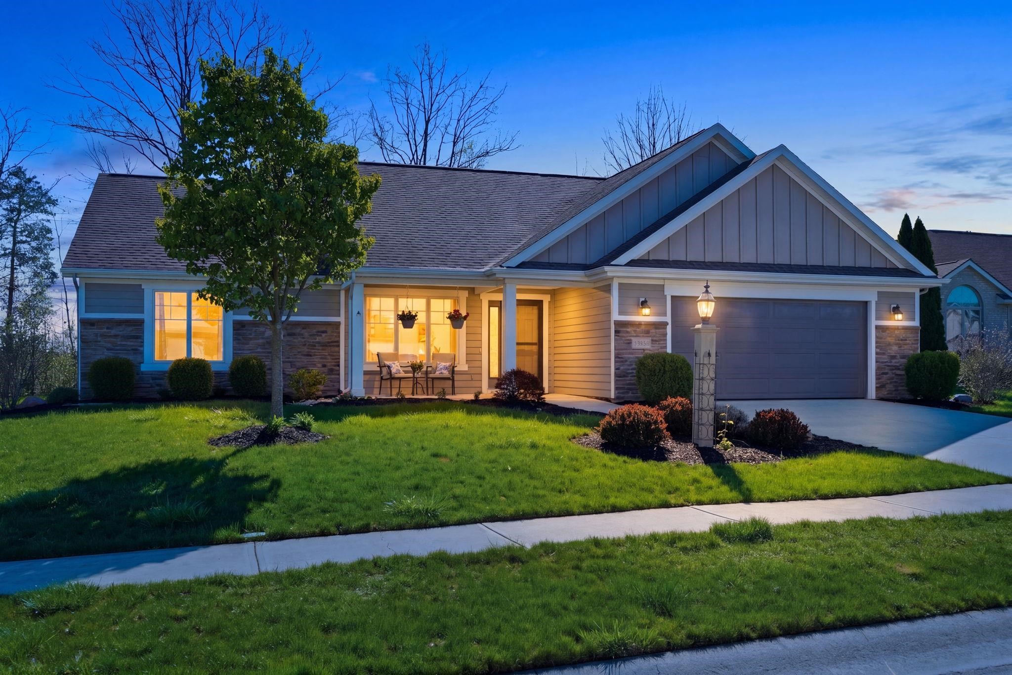 View of front of house with stone siding, board and batten siding, a garage, and concrete driveway