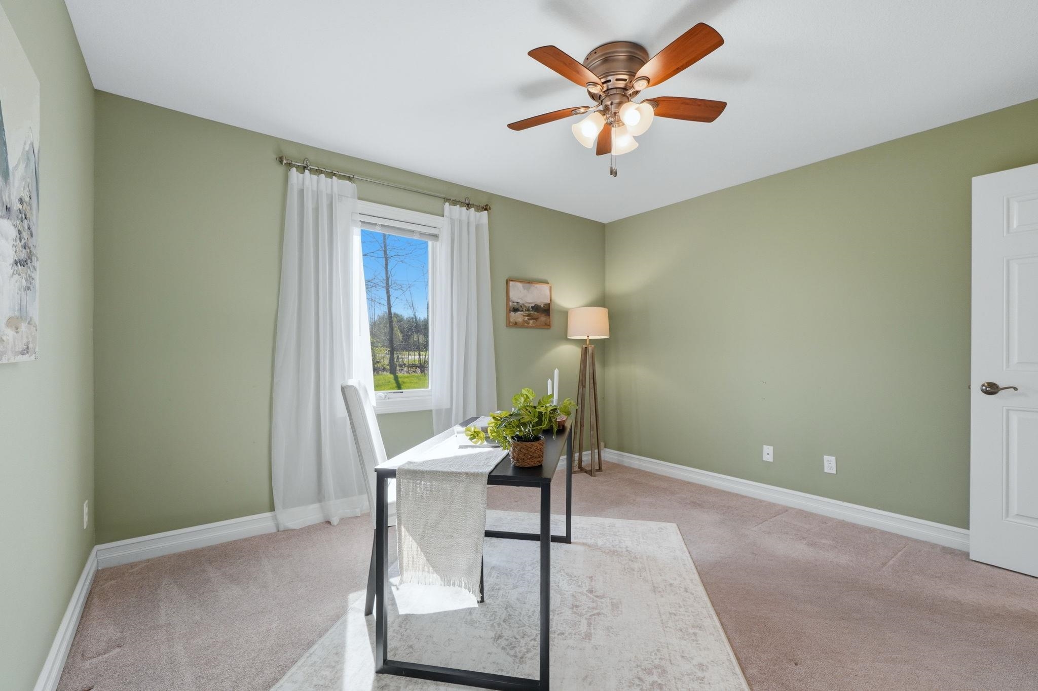 Office area with light carpet and ceiling fan