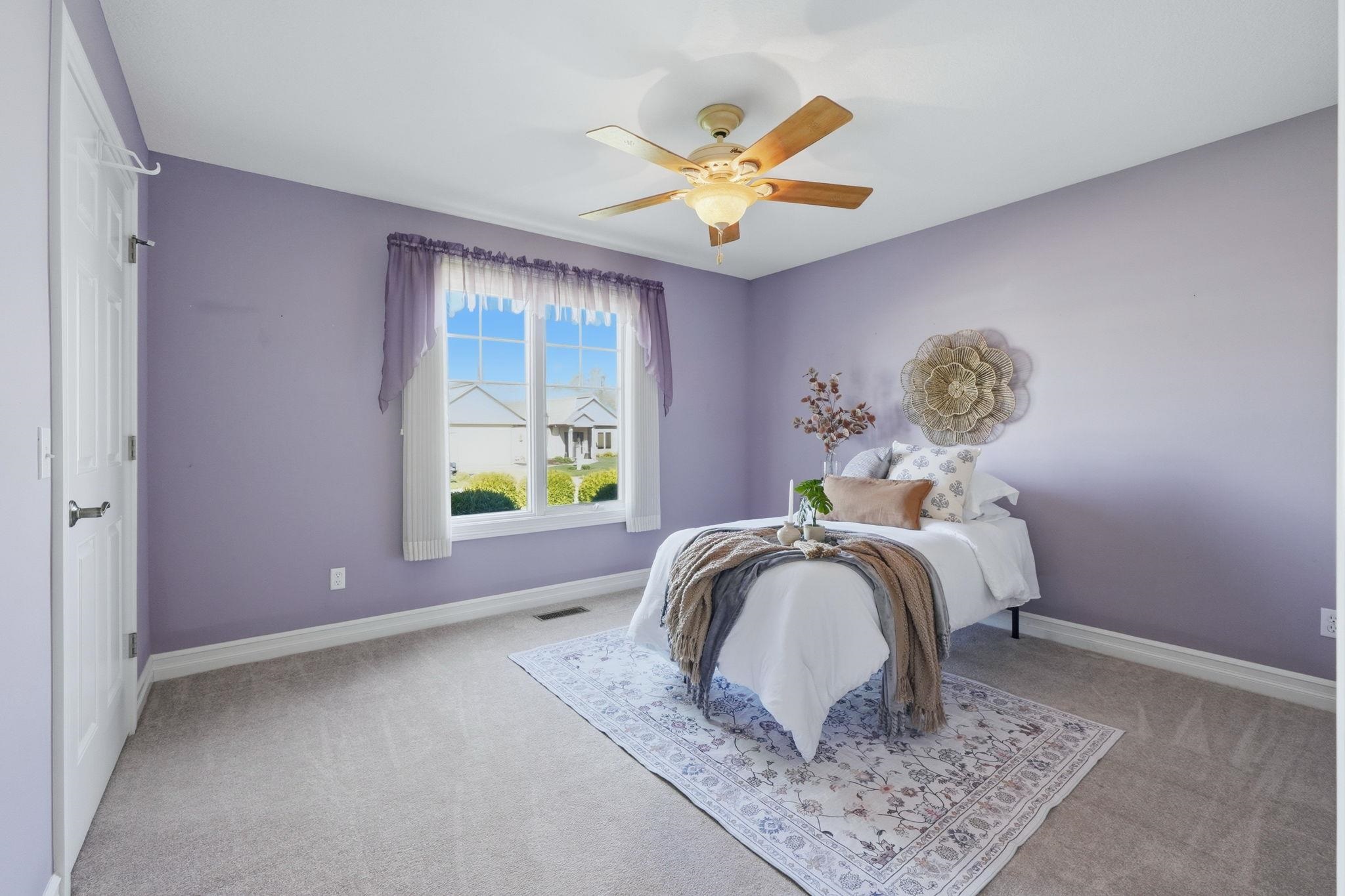 Bedroom featuring a ceiling fan and light colored carpet
