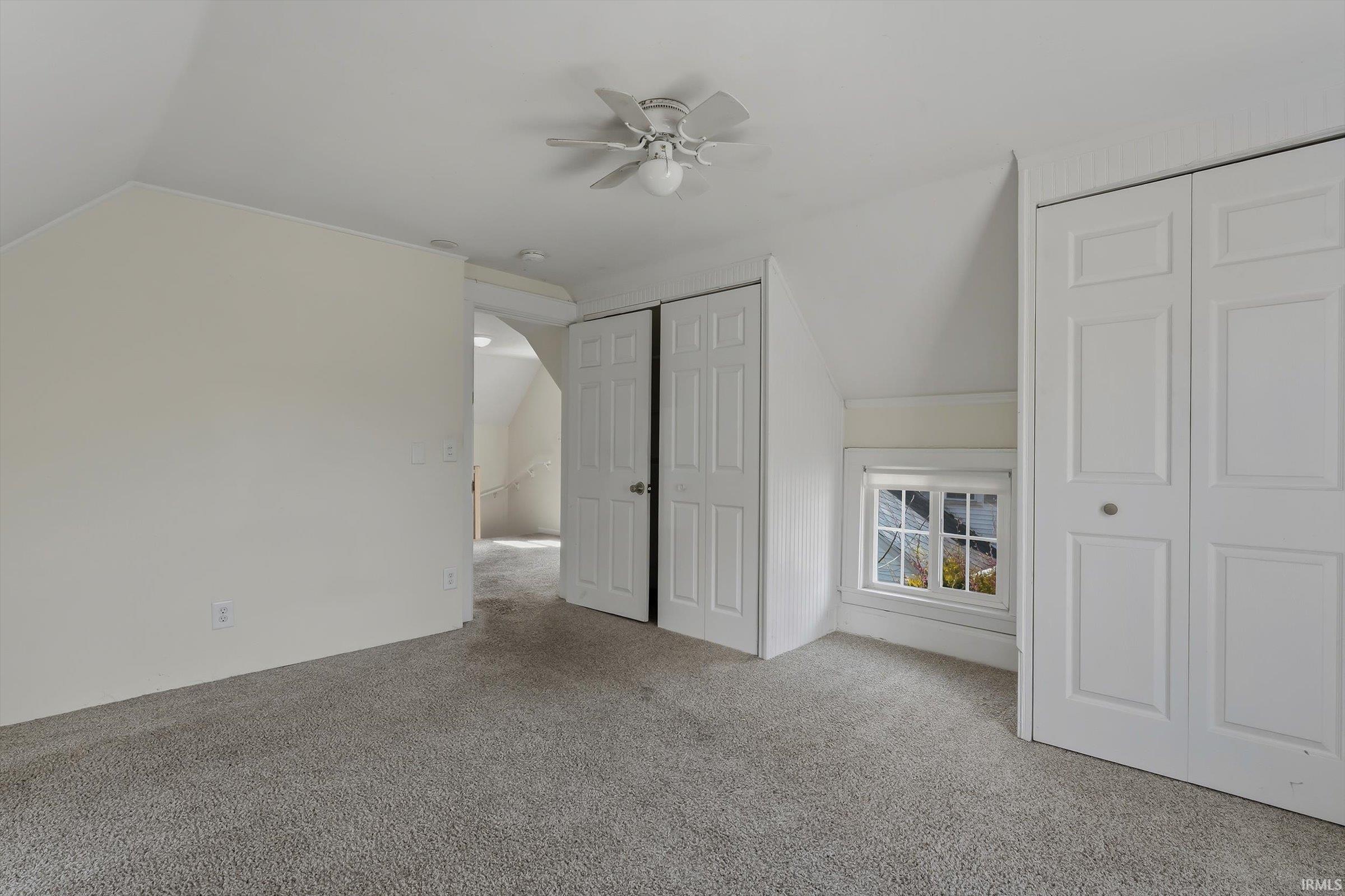 Bonus room featuring vaulted ceiling, carpet flooring, and ceiling fan