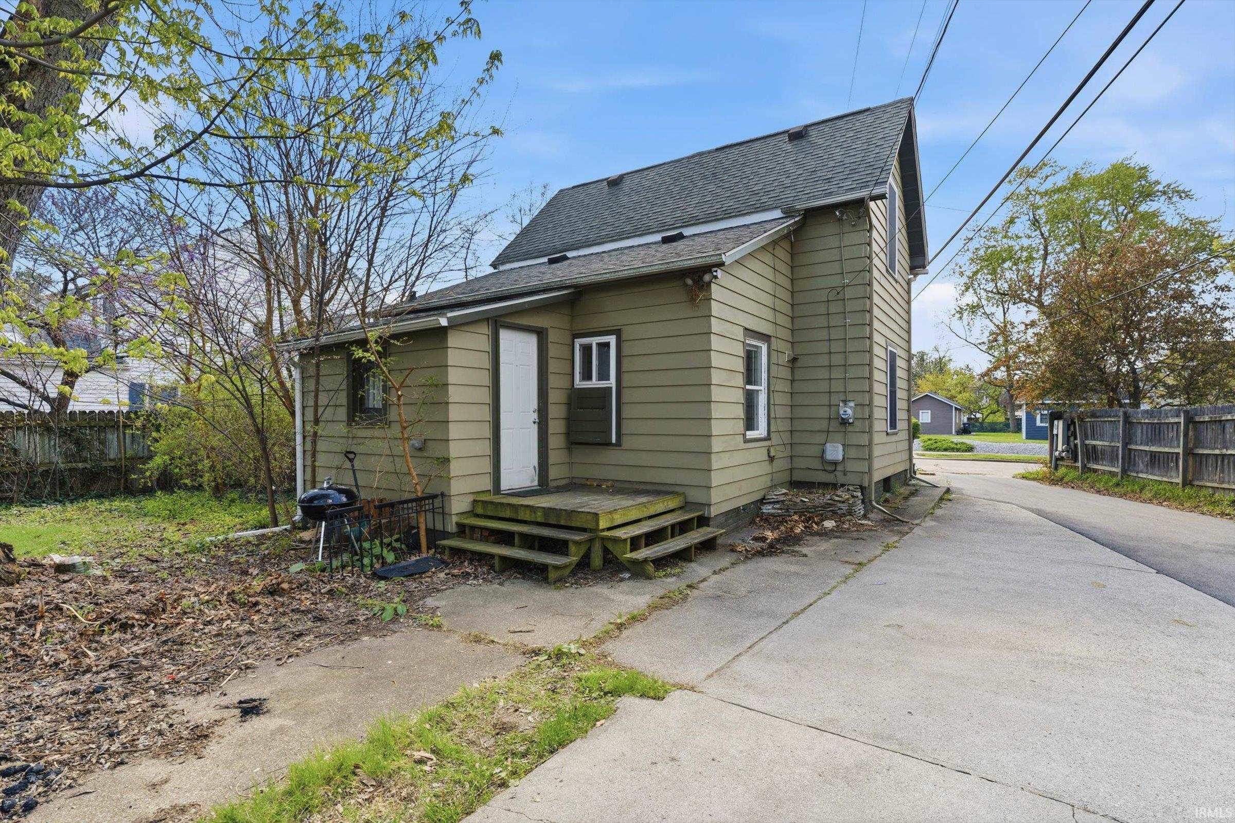 Back of house featuring roof with shingles