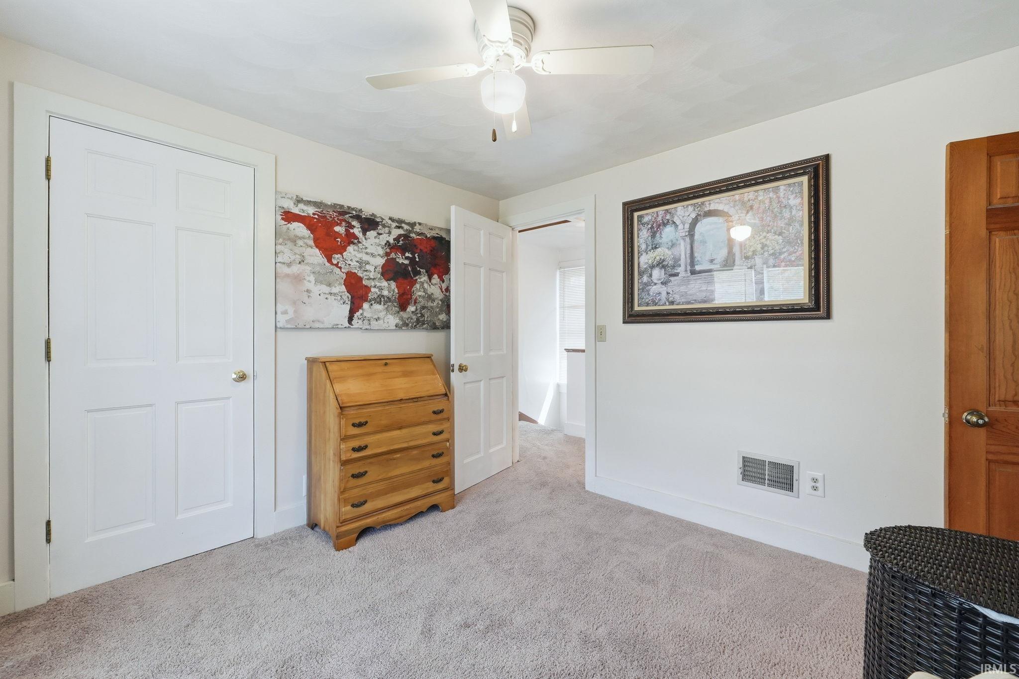Neutral-toned wall-to-wall carpeting complements light-colored walls