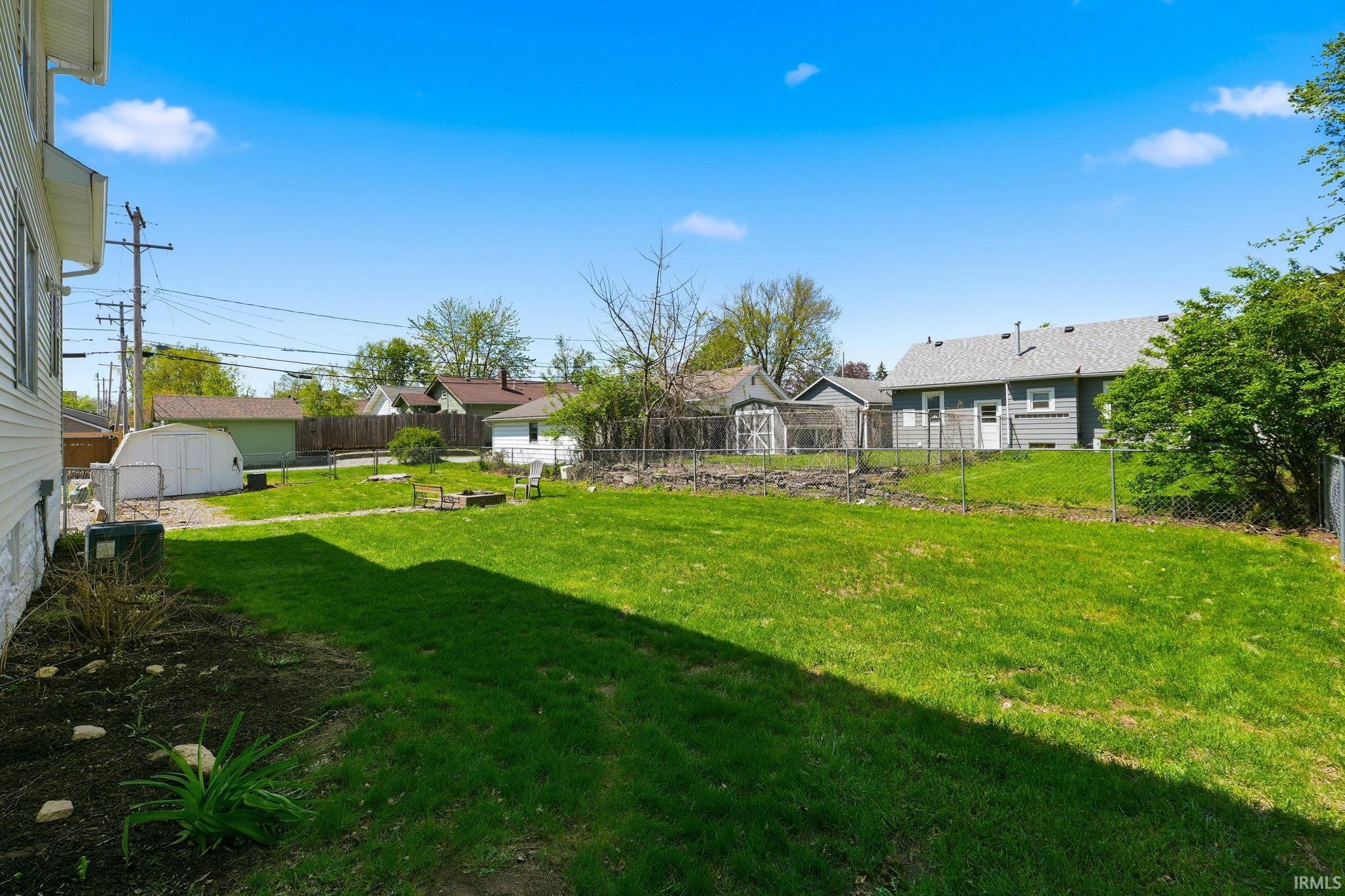 Expansive green lawn with established landscaping beds along the property perimeter