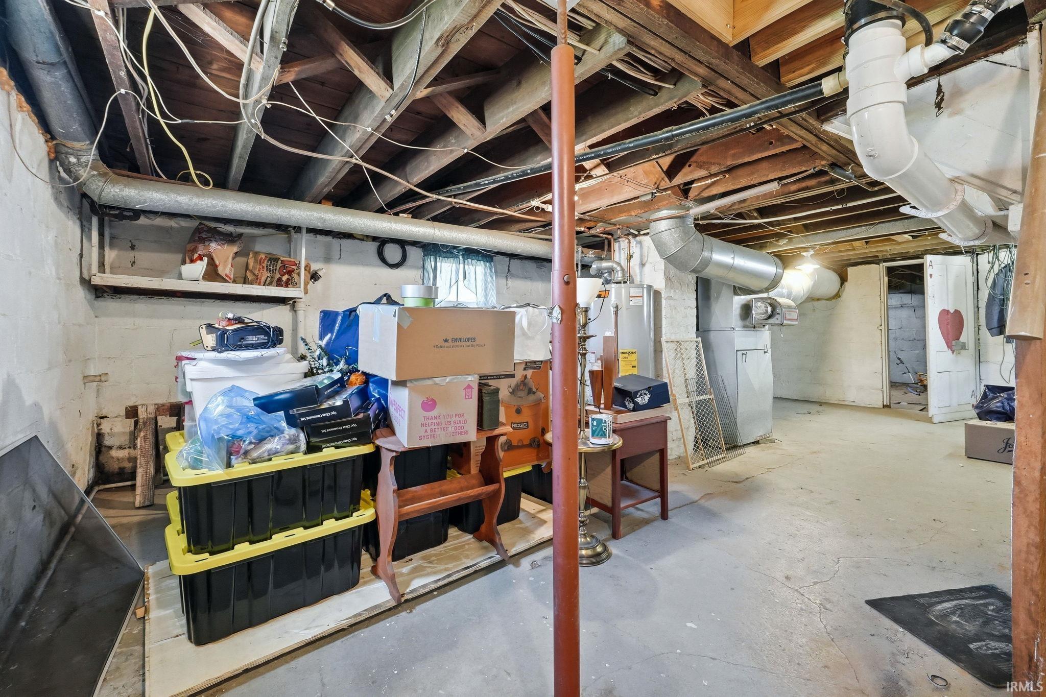 Basement space featuring exposed wood joists, concrete flooring, and visible ductwork