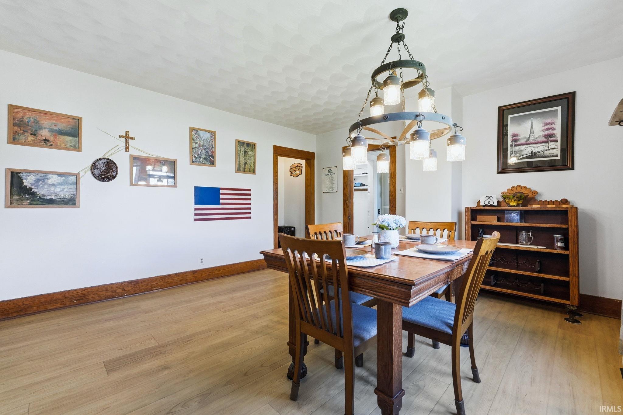 Dining area featuring light wood-finish flooring and white walls with dark wood trim