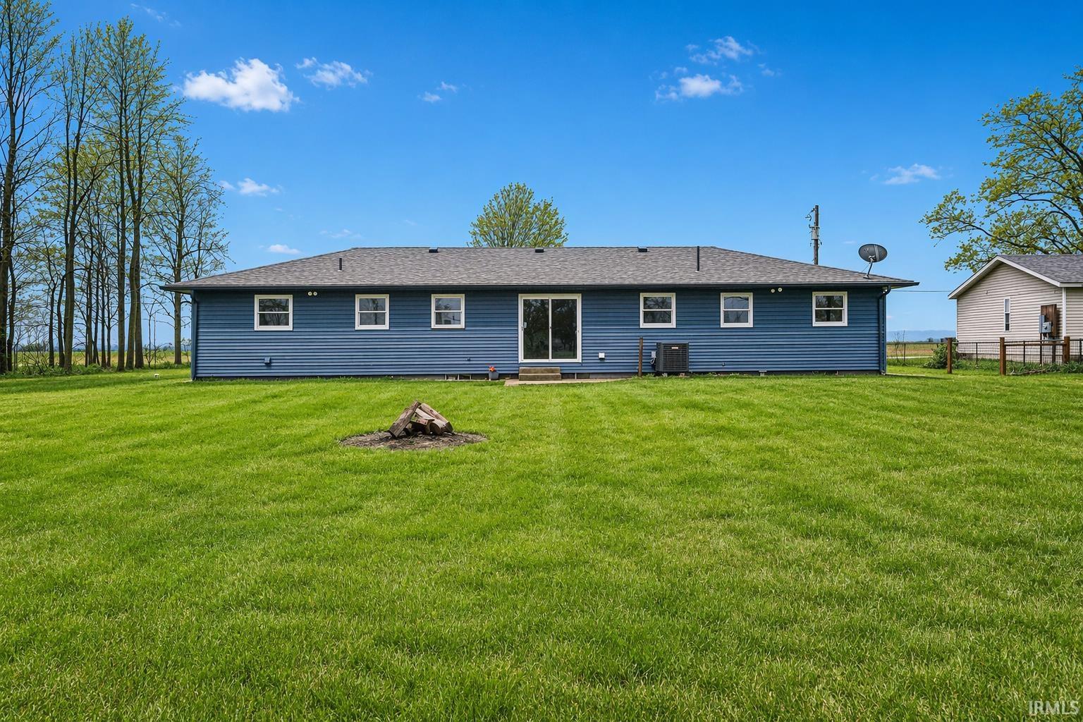 Back of property with a lawn, a shingled roof, and entry steps