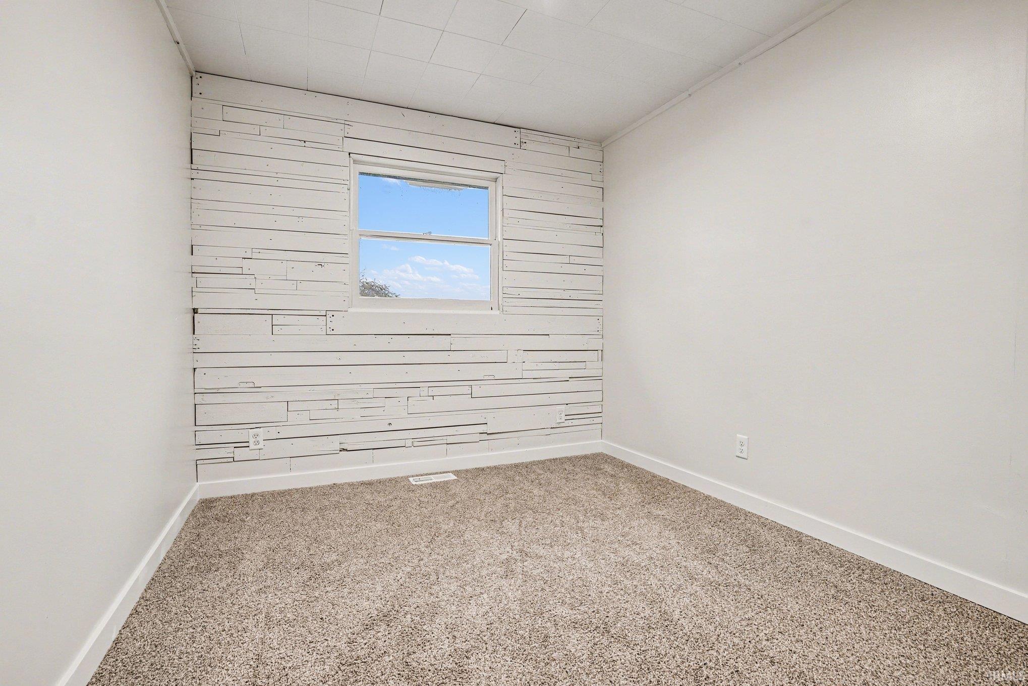 Empty room featuring light carpet and baseboards