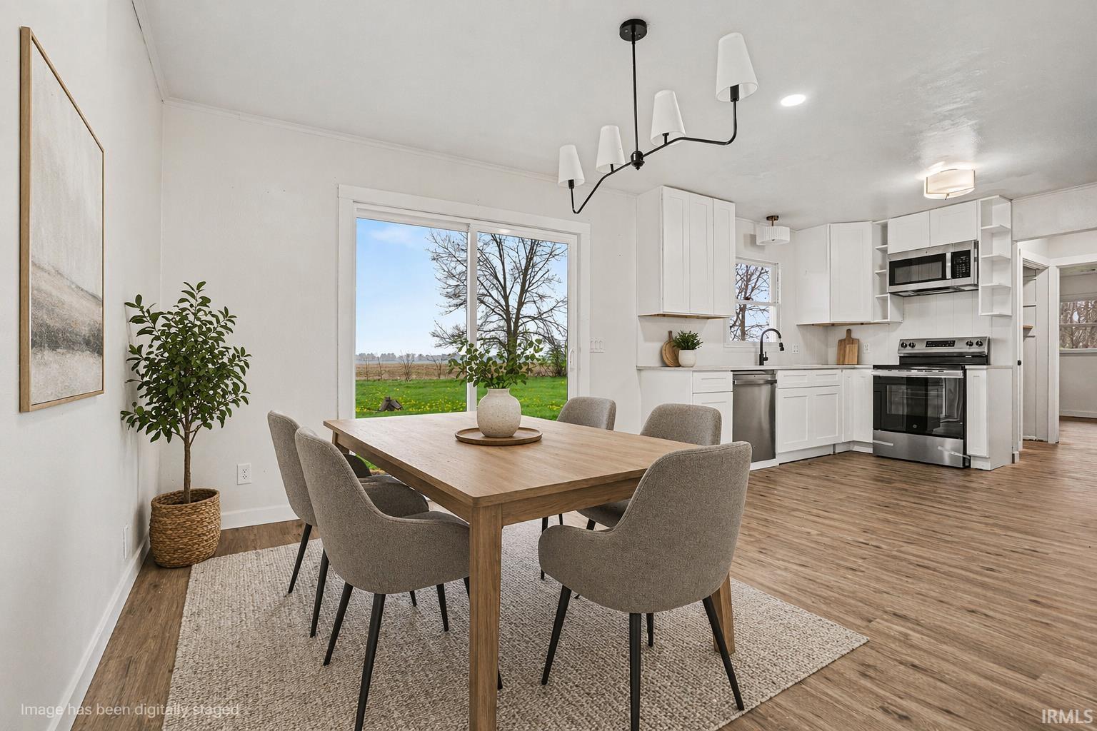 Dining room with light wood-style floors and recessed lighting.Virtually staged