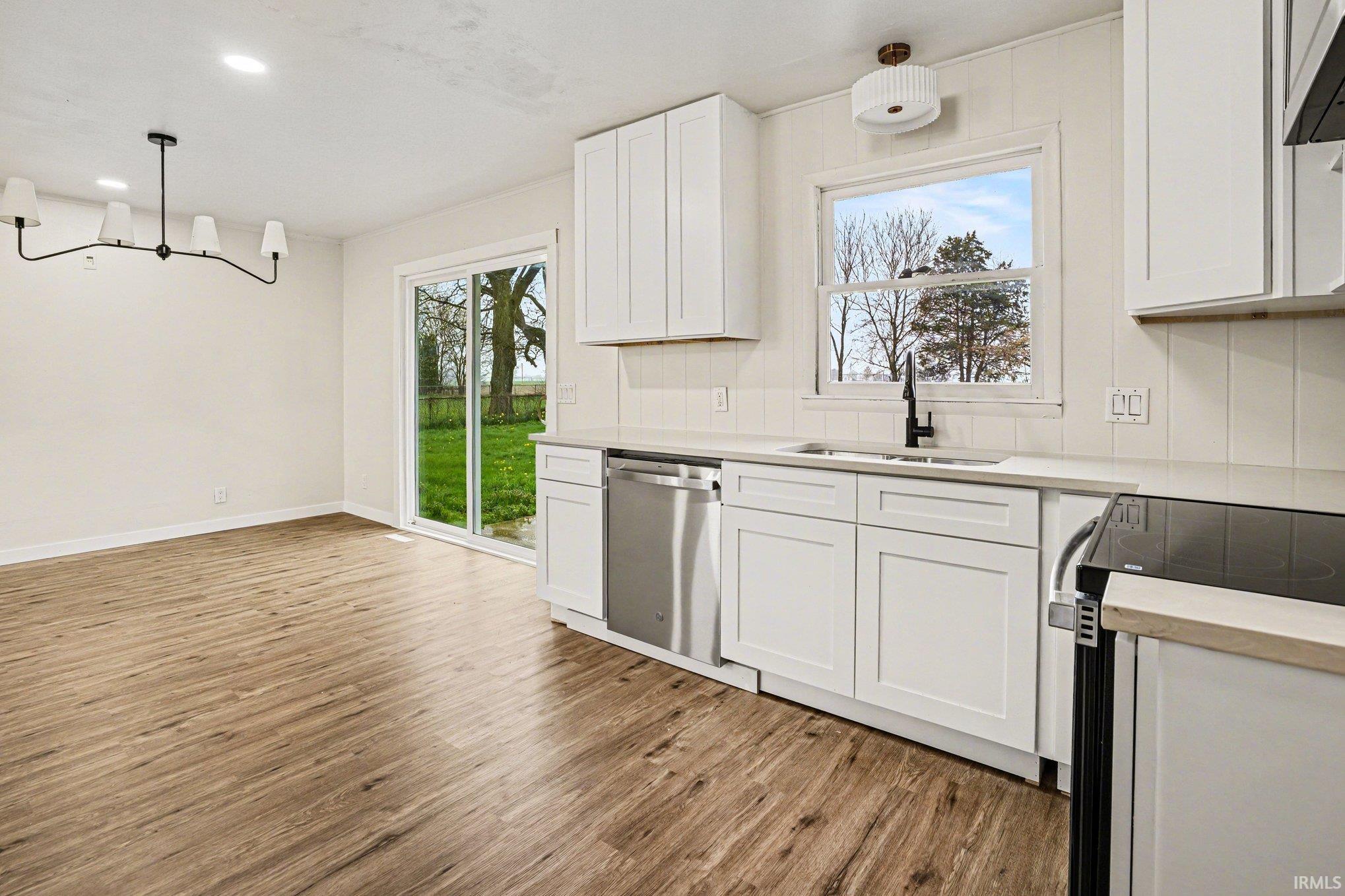 Kitchen featuring range with electric cooktop, white cabinets, dark wood-style flooring, and dishwasher