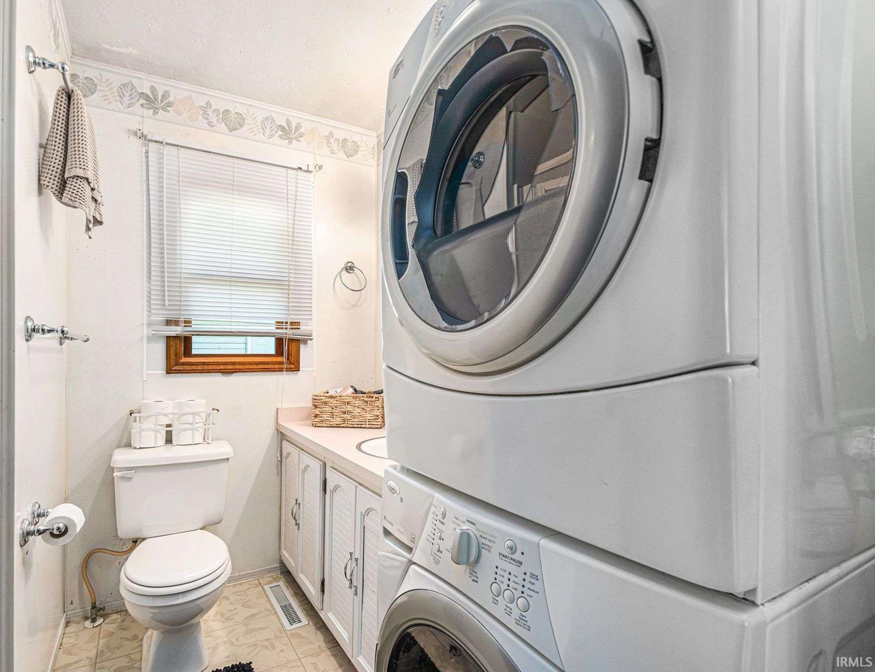 Dedicated laundry area featuring a stacked washer and dryer