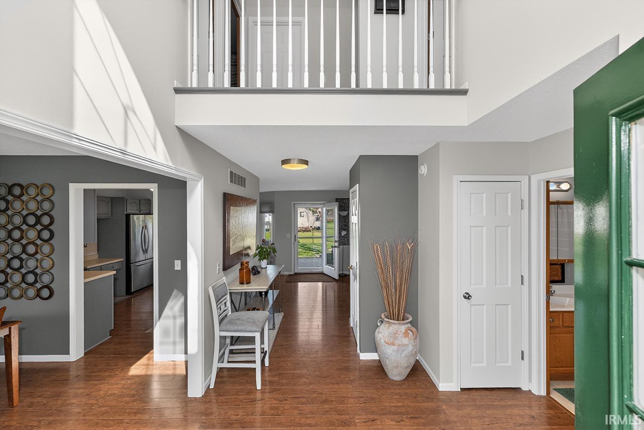 Foyer entrance featuring dark wood-type flooring and a high ceiling