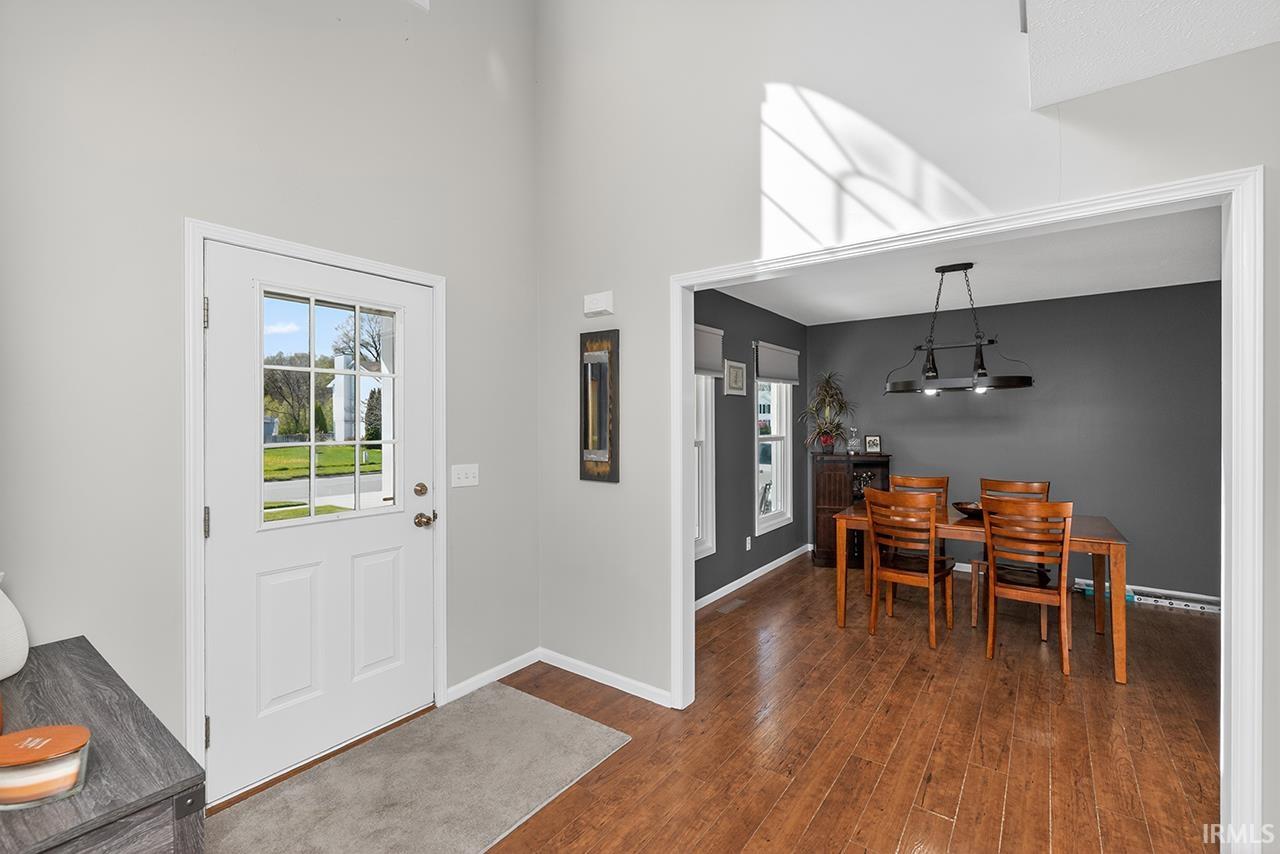 Foyer with dark wood finished floors and a high ceiling