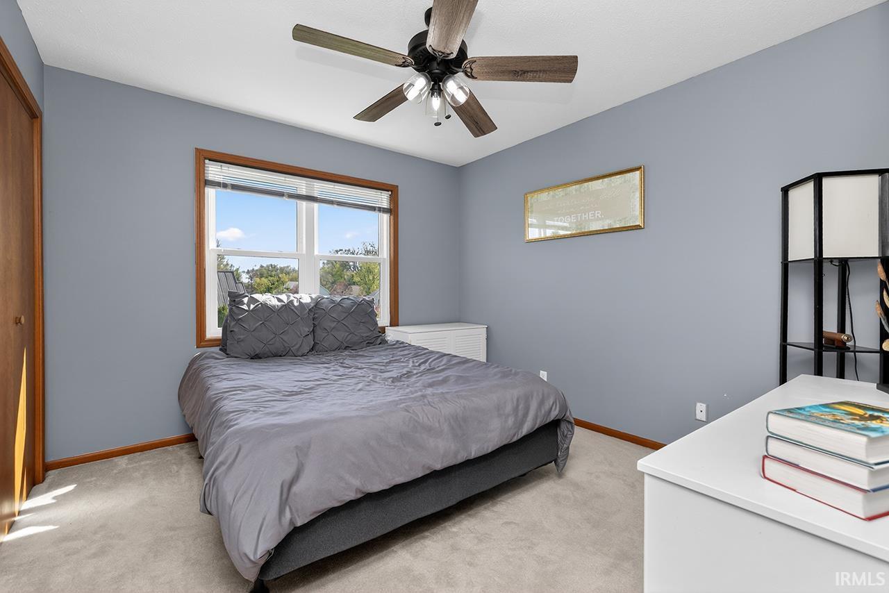 Bedroom featuring light colored carpet, a closet, and a ceiling fan