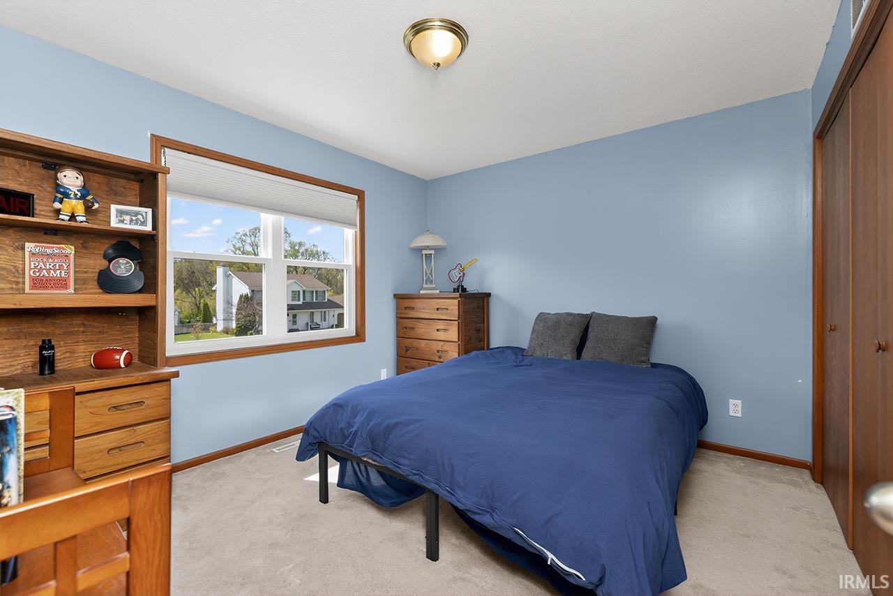 Bedroom featuring light carpet and a closet