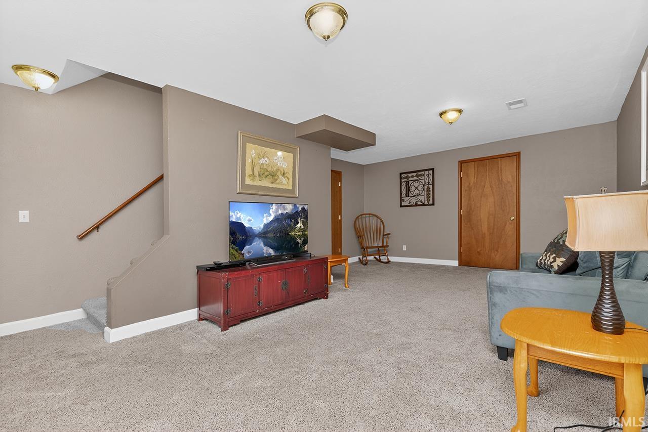 Living room featuring light colored carpet and baseboards