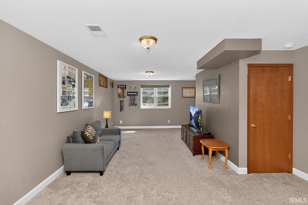 Sitting room with baseboards and light colored carpet