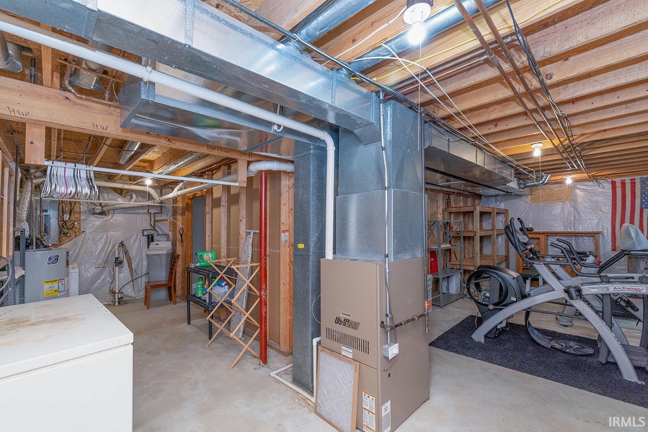 Unfinished basement with heating unit and gas water heater