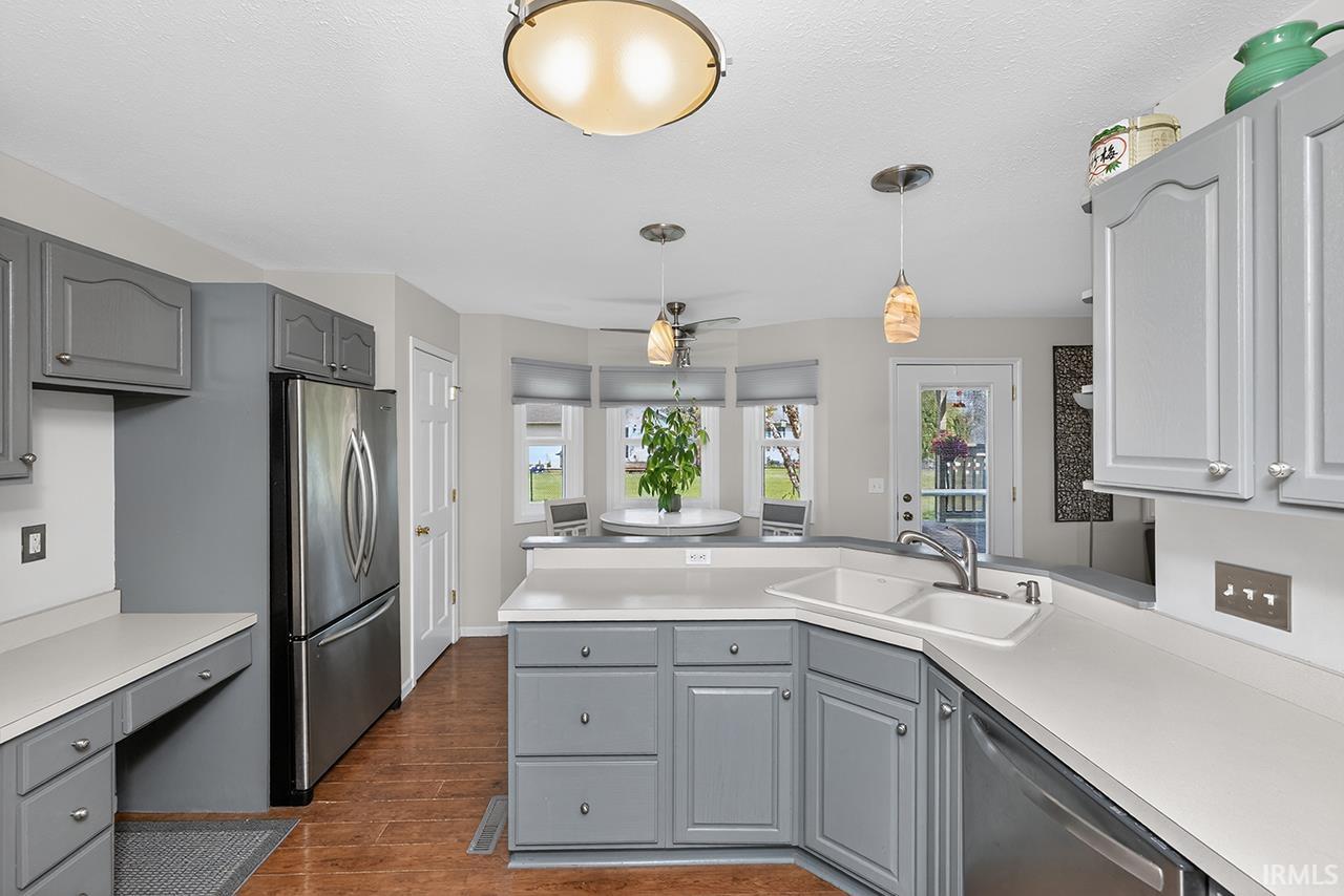 Kitchen with gray cabinetry, stainless steel appliances, healthy amount of natural light, and light countertops