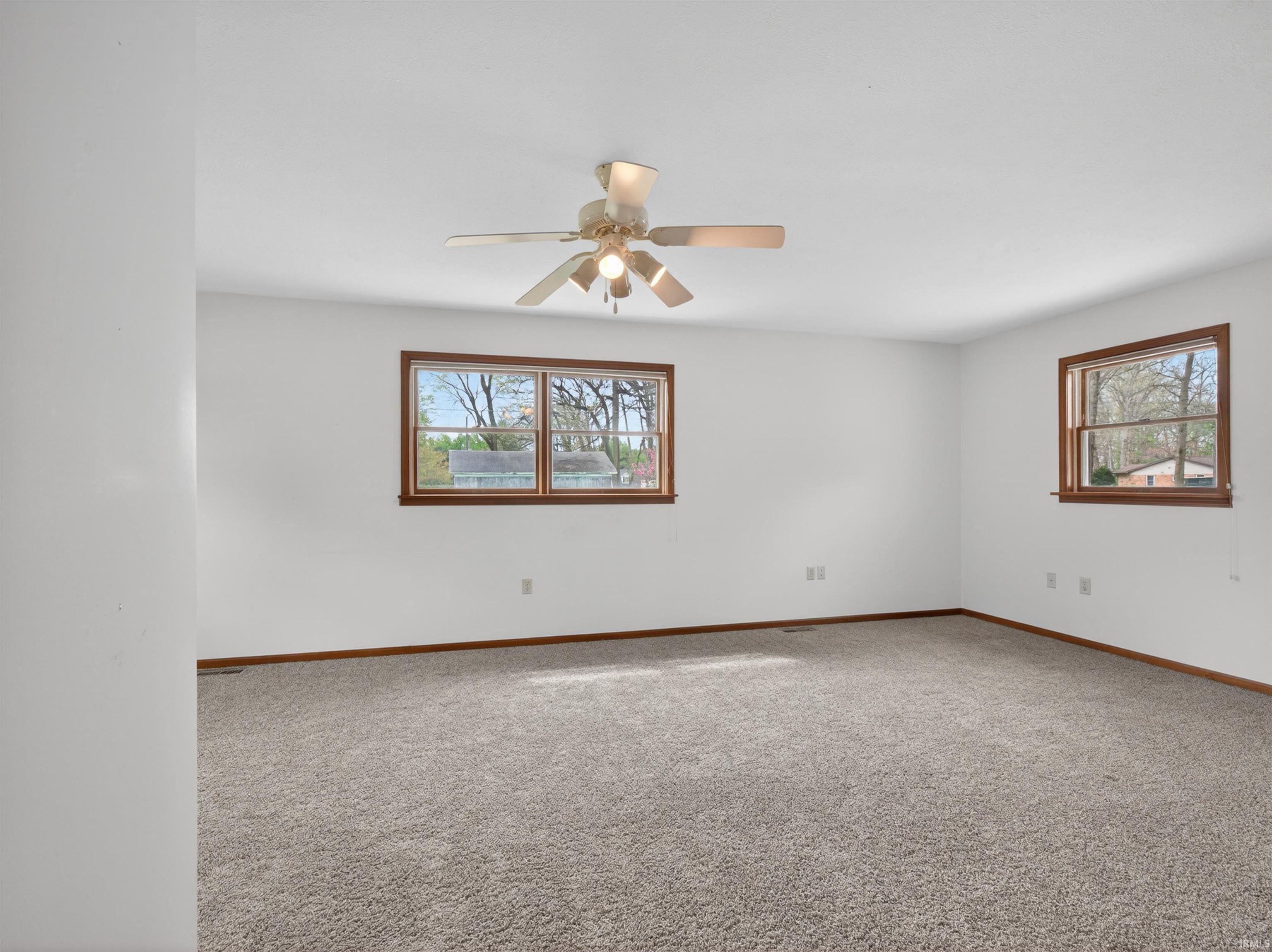 Spacious room featuring neutral carpeting and white painted walls