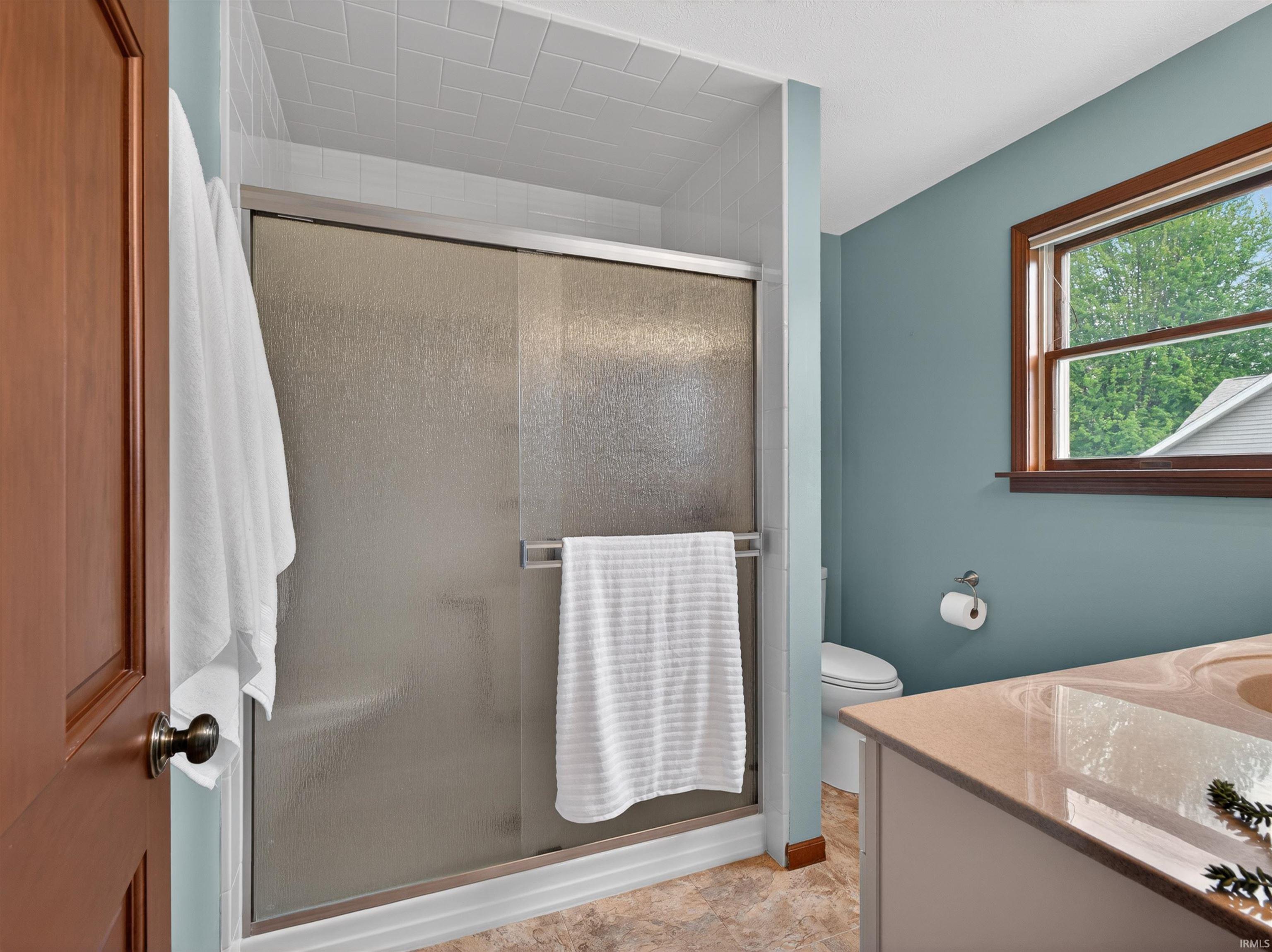 Frosted glass shower enclosure with white subway tile surround