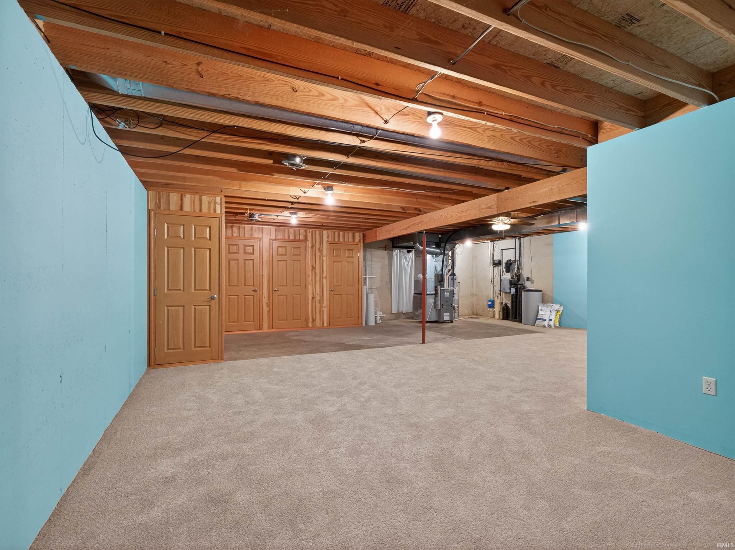 Lower level featuring exposed wood beam ceiling, plush carpet flooring, recessed lighting, and panel doors