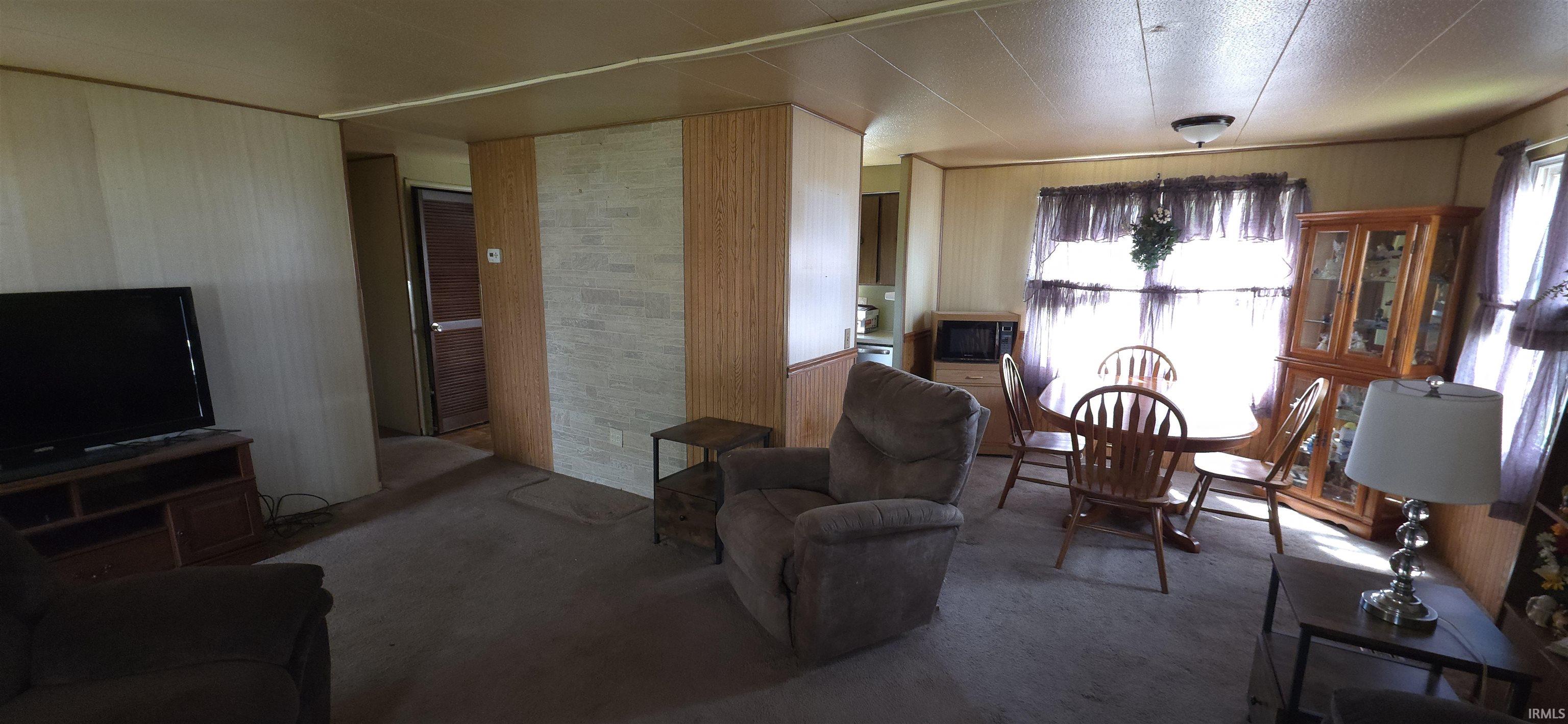 Carpeted living room with wooden walls