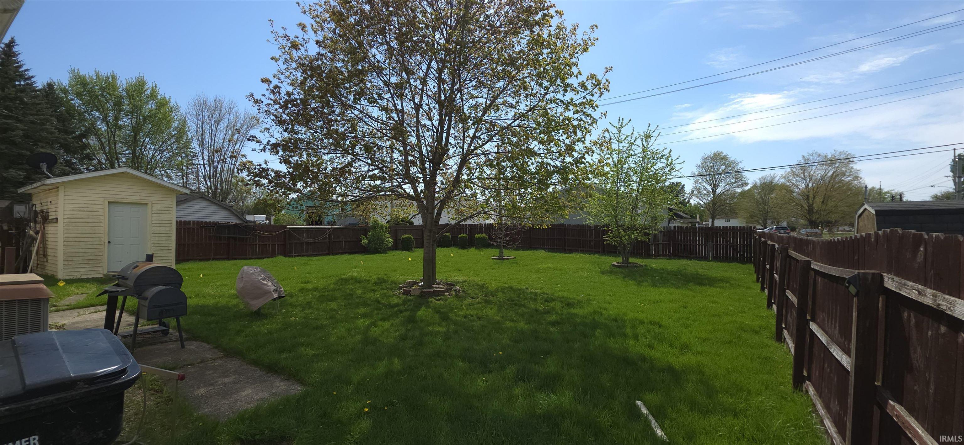 Fenced backyard with an outbuilding